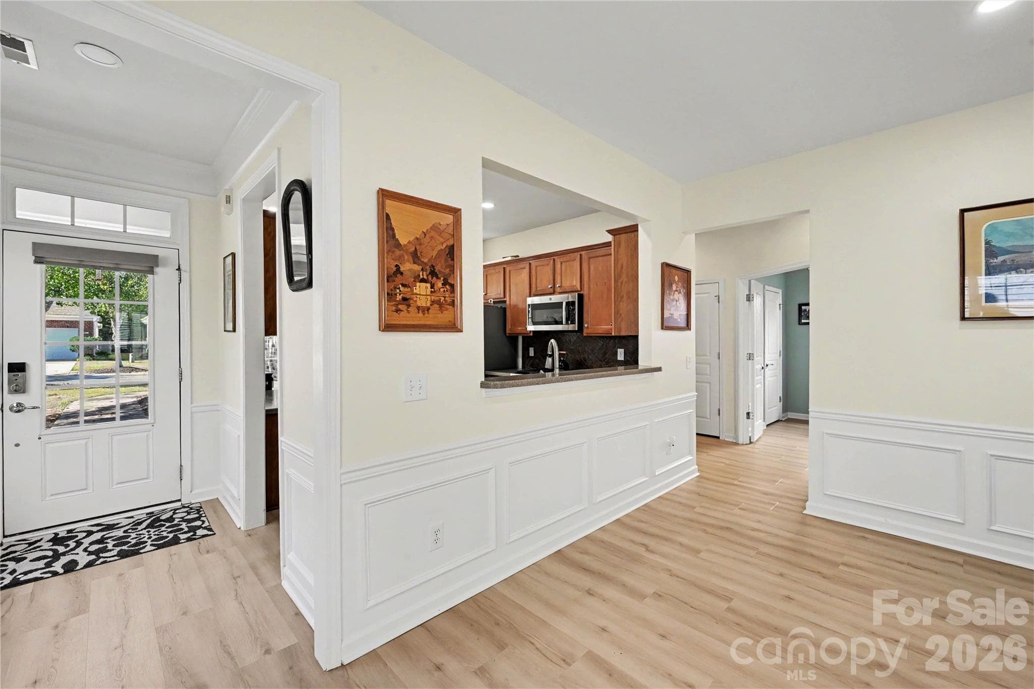 View of the Dining Area looking towards the Kitchen showing extensive Chair Rail and Wainscoting, neutral paint, and NEW LVP Flooring. - 3054 Azalea Drive, Indian Land