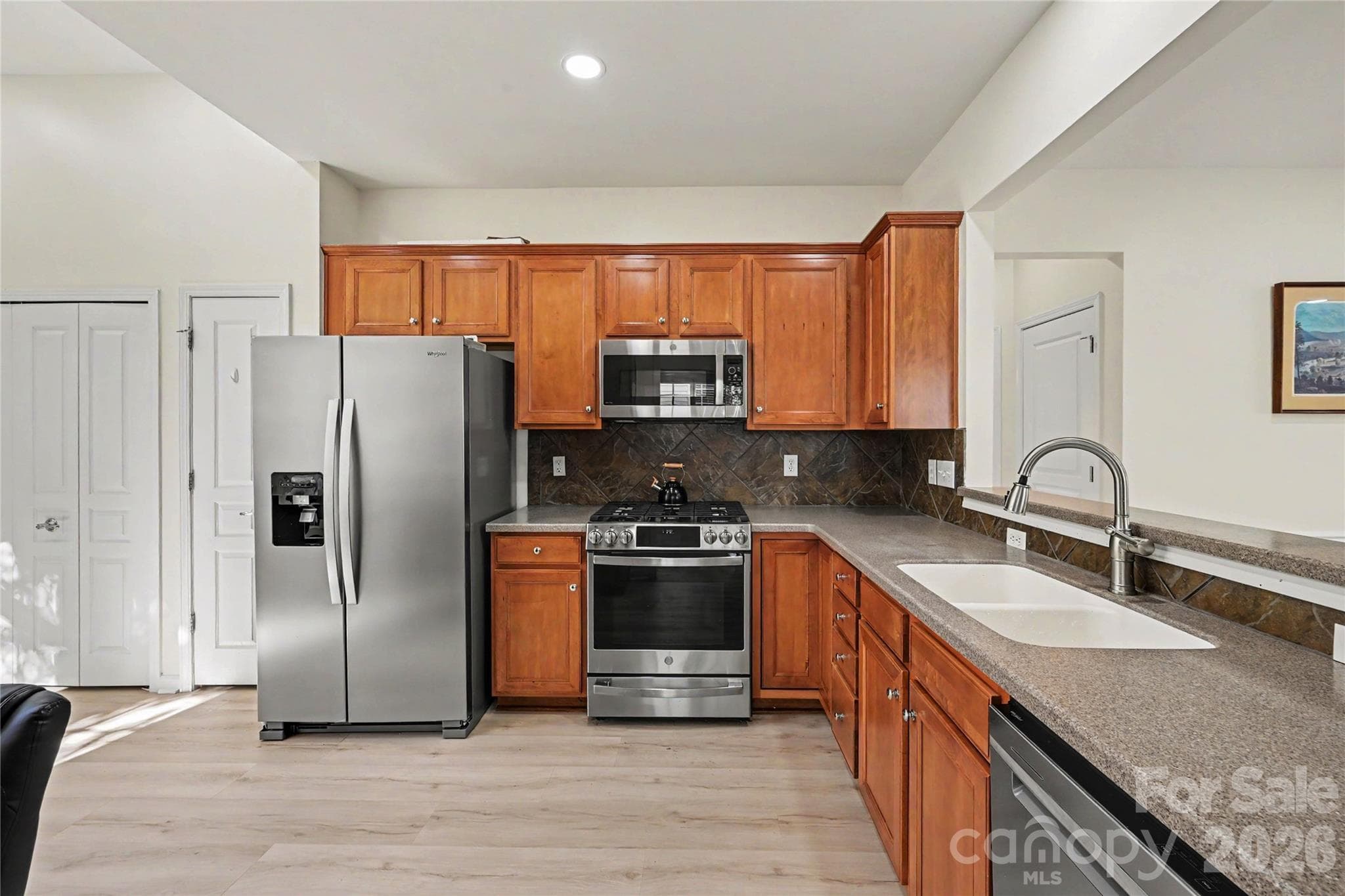 Kitchen showing SS Appliances including GAS Range and upgraded Dishwasher and Microwave, LVP flooring, and ample cabinet space. - 3054 Azalea Drive, Indian Land