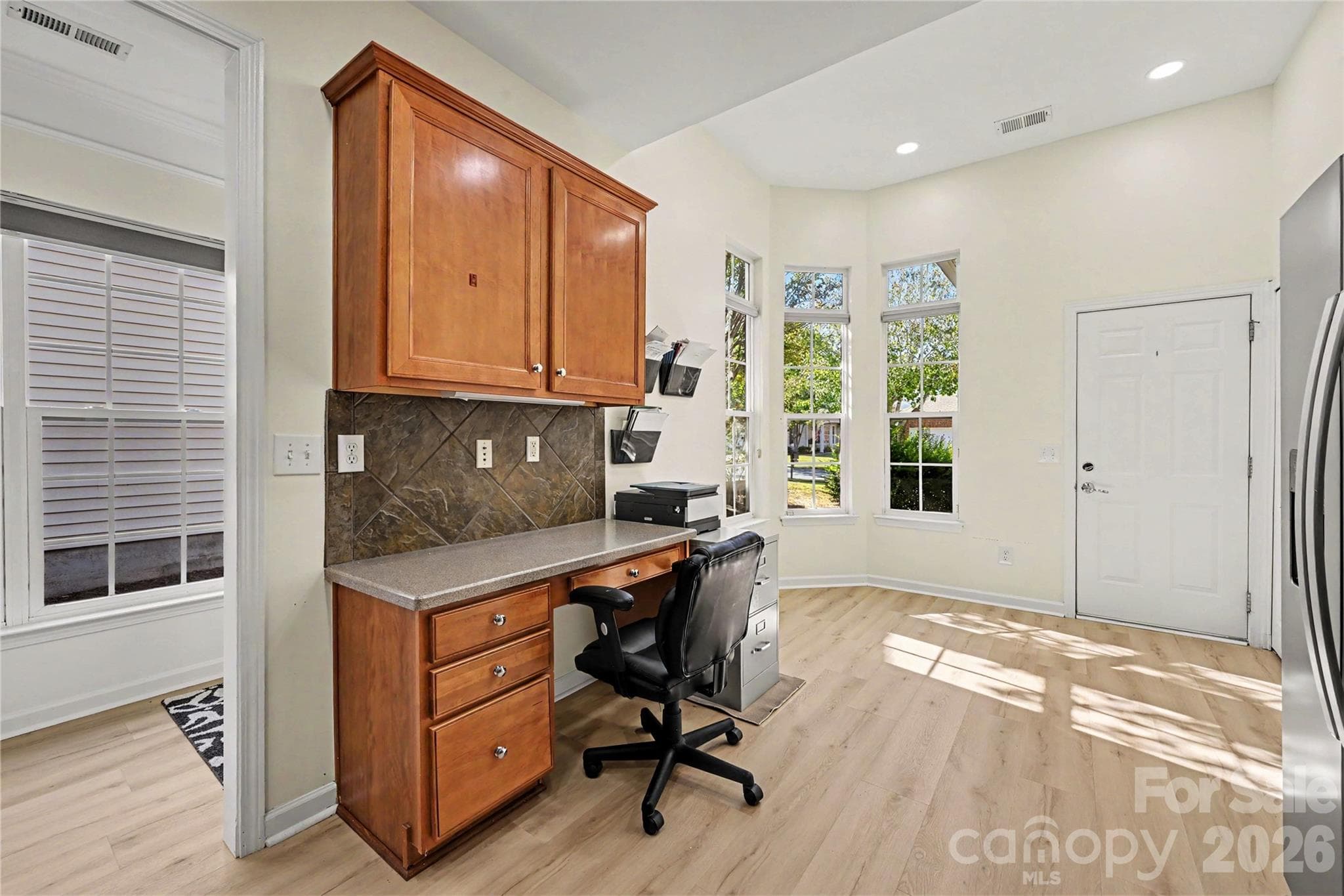 Kitchen view showing Desk and Cabinets, Breakfast area with Bay Windows, and access to the Garage. - 3054 Azalea Drive, Indian Land
