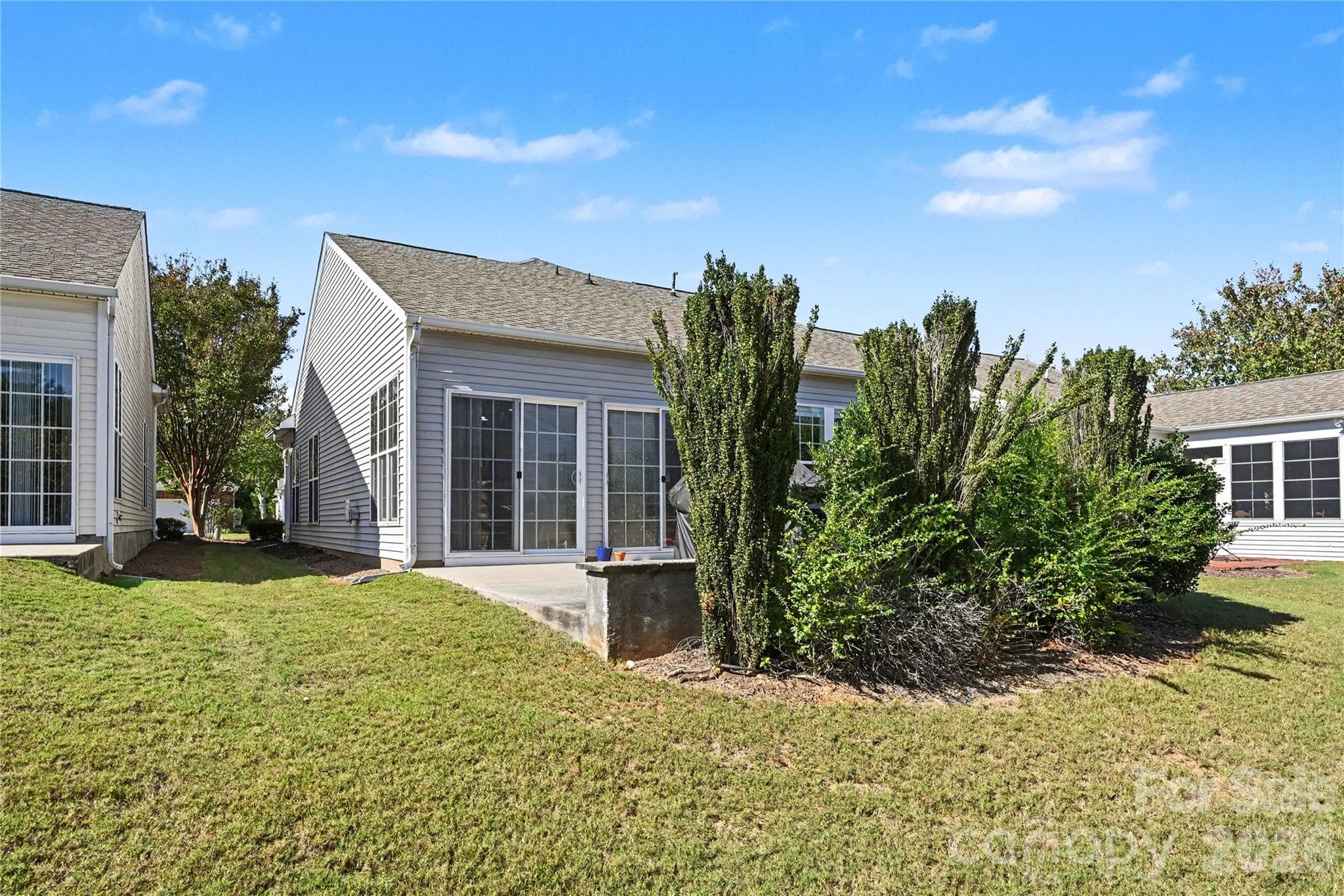 View of Back of Home showing patio, mature landscaping and Knee Wall. - 3054 Azalea Drive, Indian Land