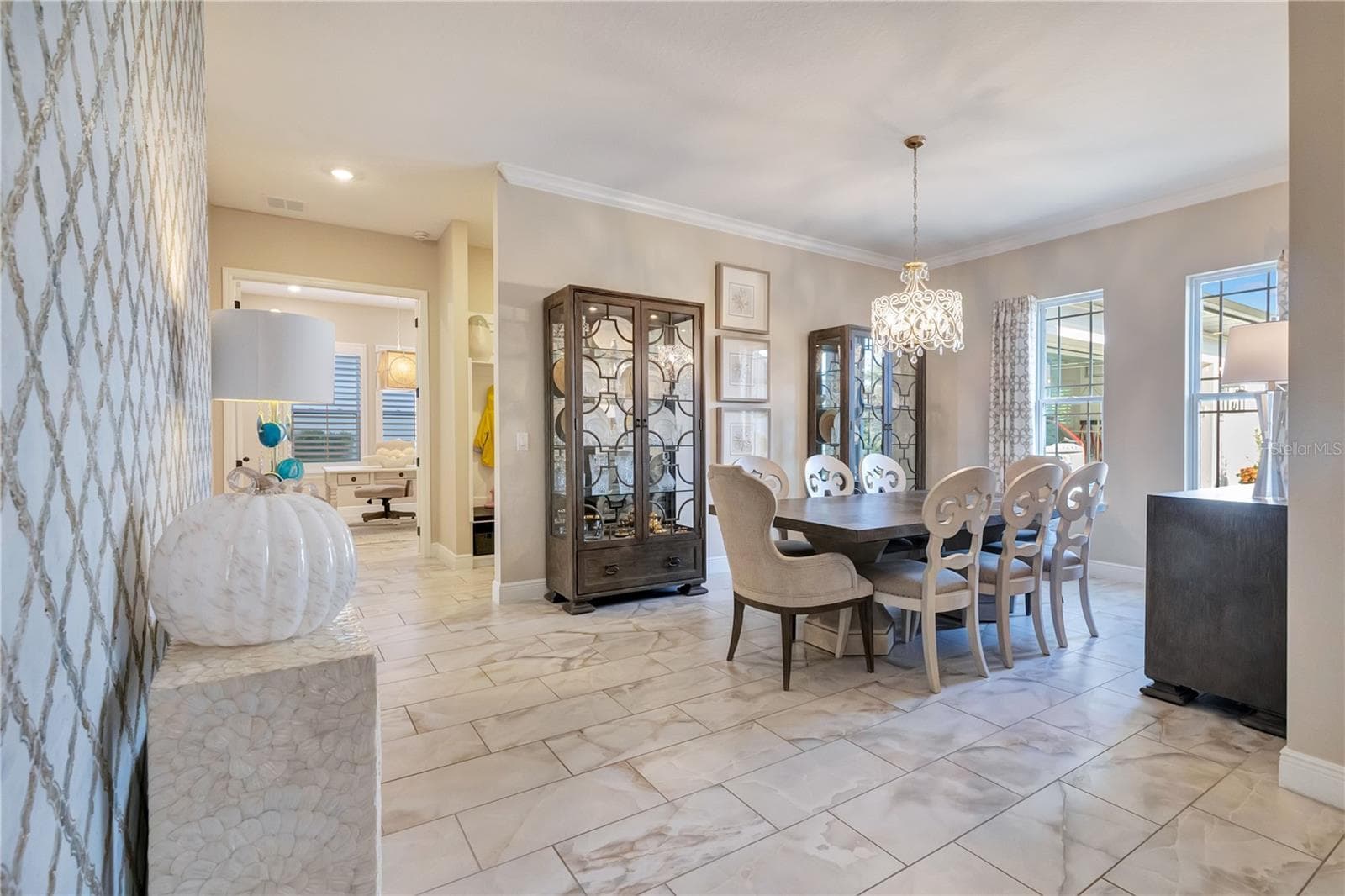Elegant dining room featuring a statement chandelier, crown molding and upgraded tile flooring. - 17600 LAKE STAR RD, WINTER GARDEN