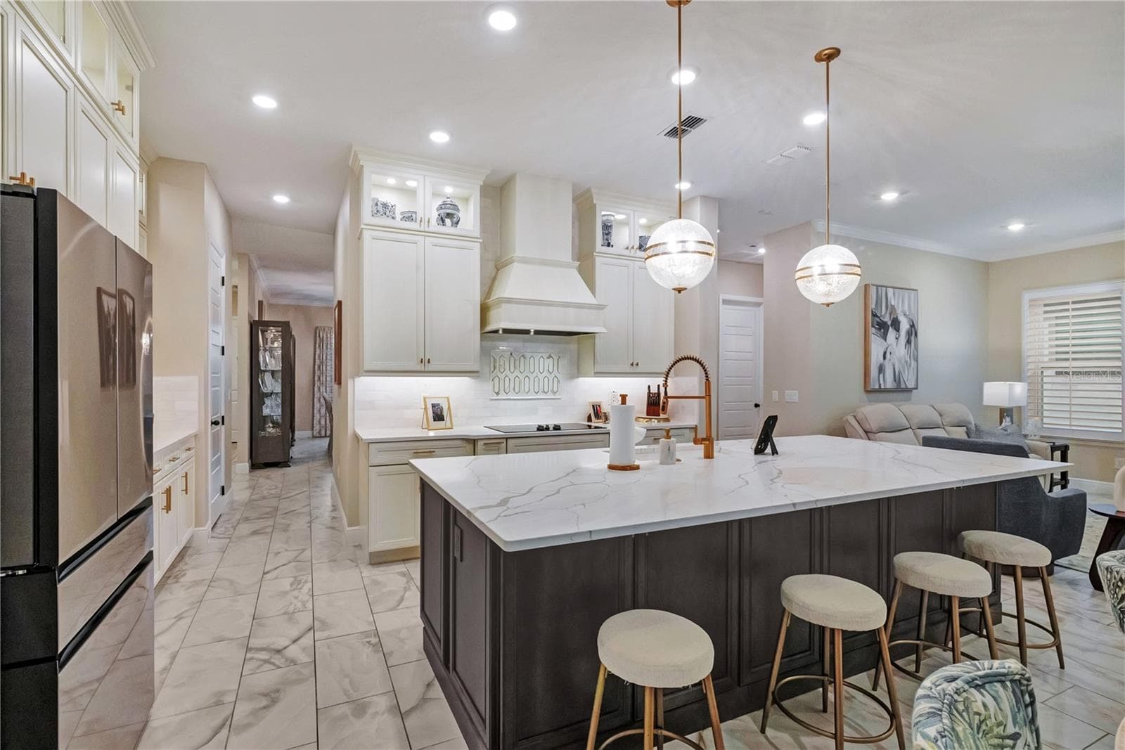 Upgraded kitchen featuring an oversized island with seating, contrasting cabinetry and designer pendant lighting. - 17600 LAKE STAR RD, WINTER GARDEN