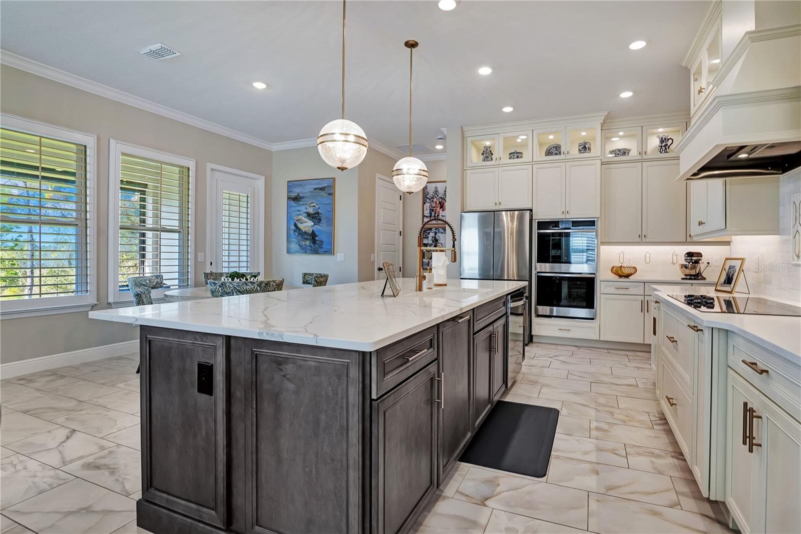 Designer kitchen with stacked cabinetry, illuminated upper display cabinets and built-in stainless steel appliances. - 17600 LAKE STAR RD, WINTER GARDEN