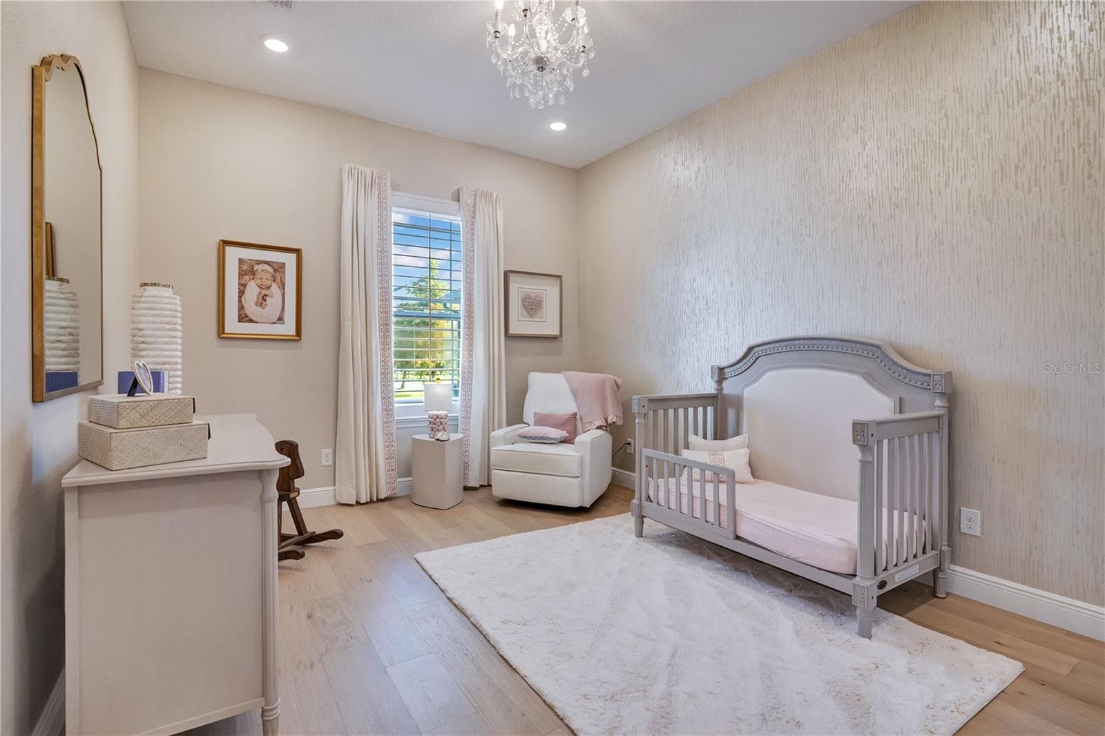 Charming bedroom featuring hardwood flooring, a decorative accent wall and chandelier lighting. - 17600 LAKE STAR RD, WINTER GARDEN