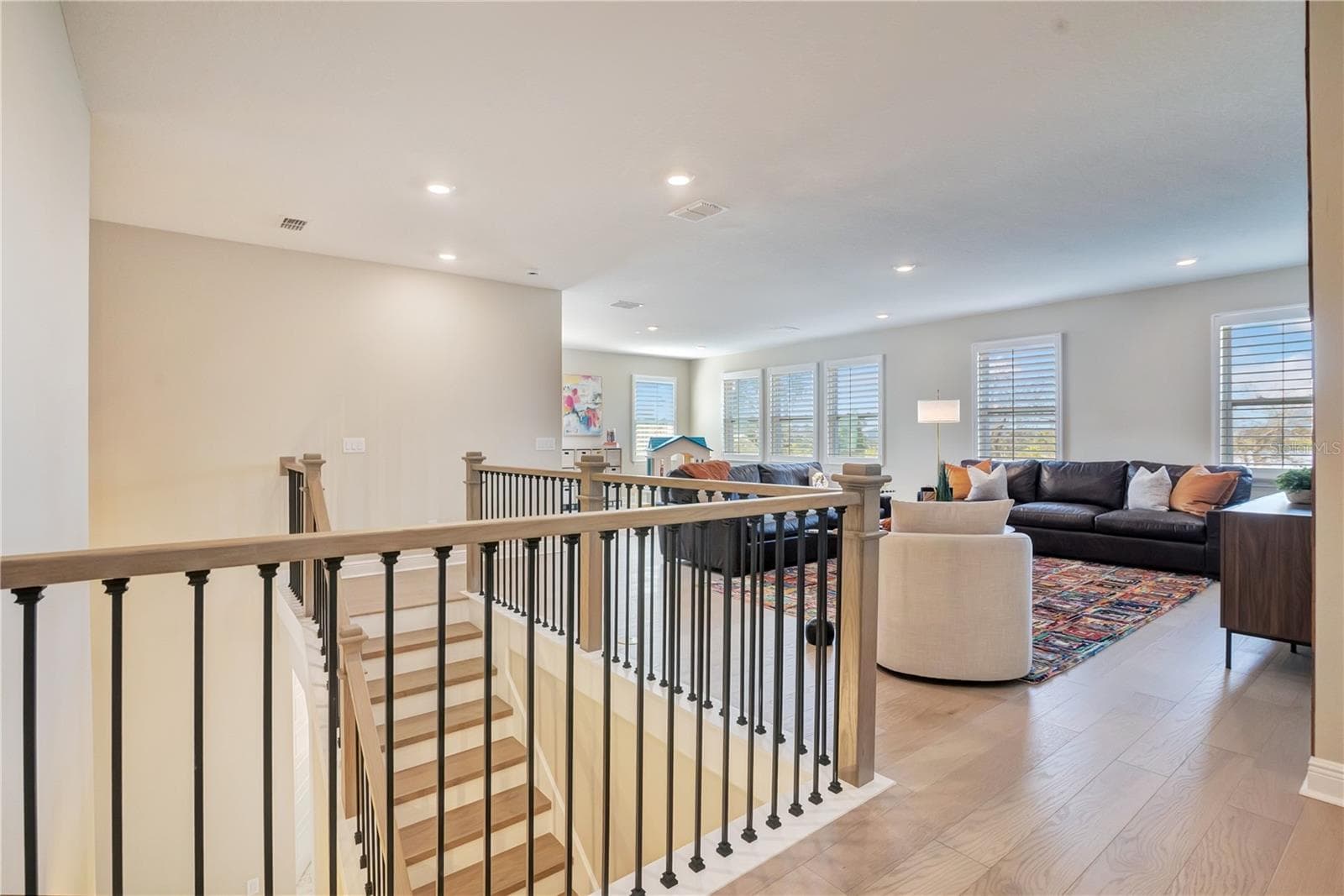 Open upstairs landing with upgraded stair railings leads into a spacious loft. - 17600 LAKE STAR RD, WINTER GARDEN