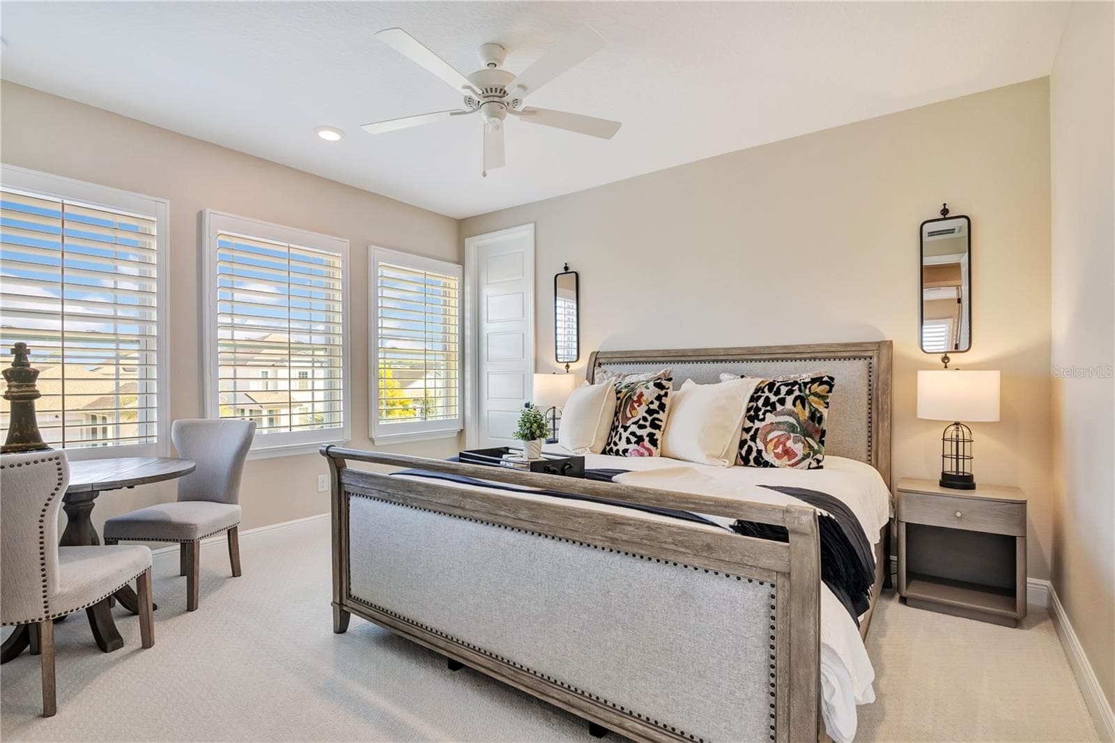 Inviting bedroom featuring plush carpet, plantation shutters and a ceiling fan. - 17600 LAKE STAR RD, WINTER GARDEN