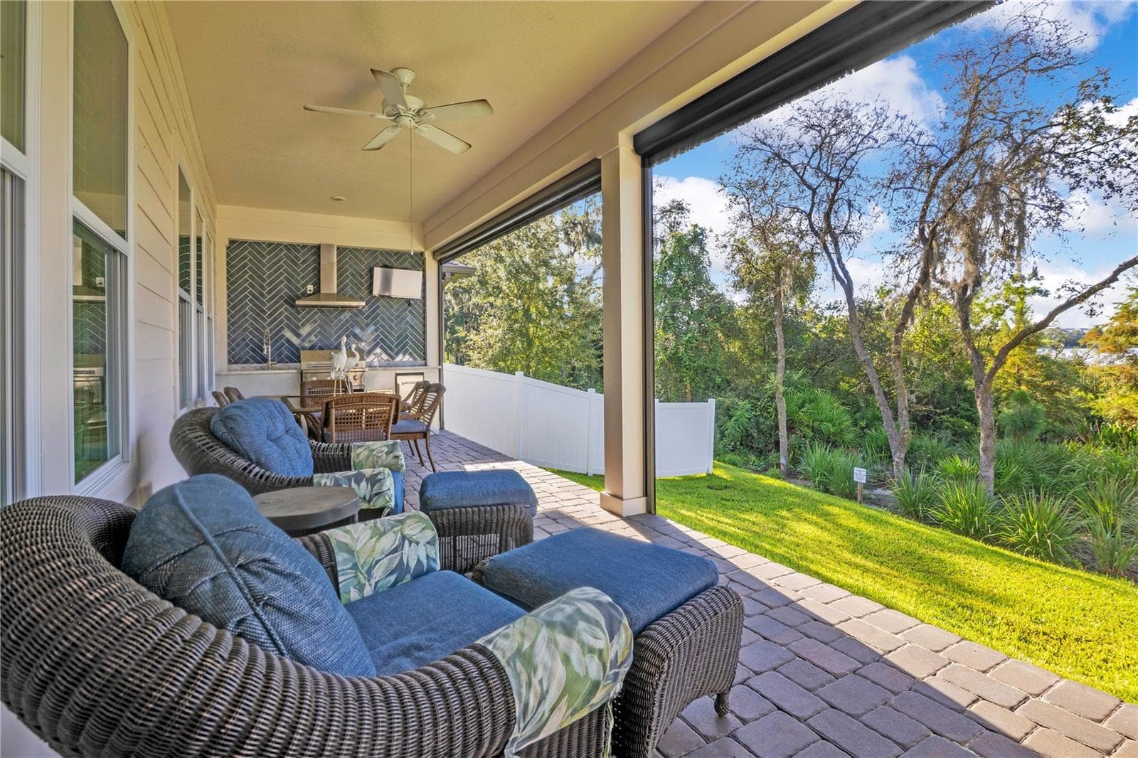 Covered paver lanai offers a relaxing outdoor lounge overlooking the backyard and mature trees. - 17600 LAKE STAR RD, WINTER GARDEN