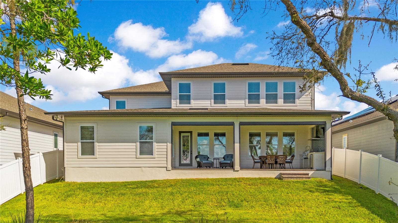 Spacious covered lanai with ceiling fans and roll-up screens extends the home’s outdoor living space. - 17600 LAKE STAR RD, WINTER GARDEN
