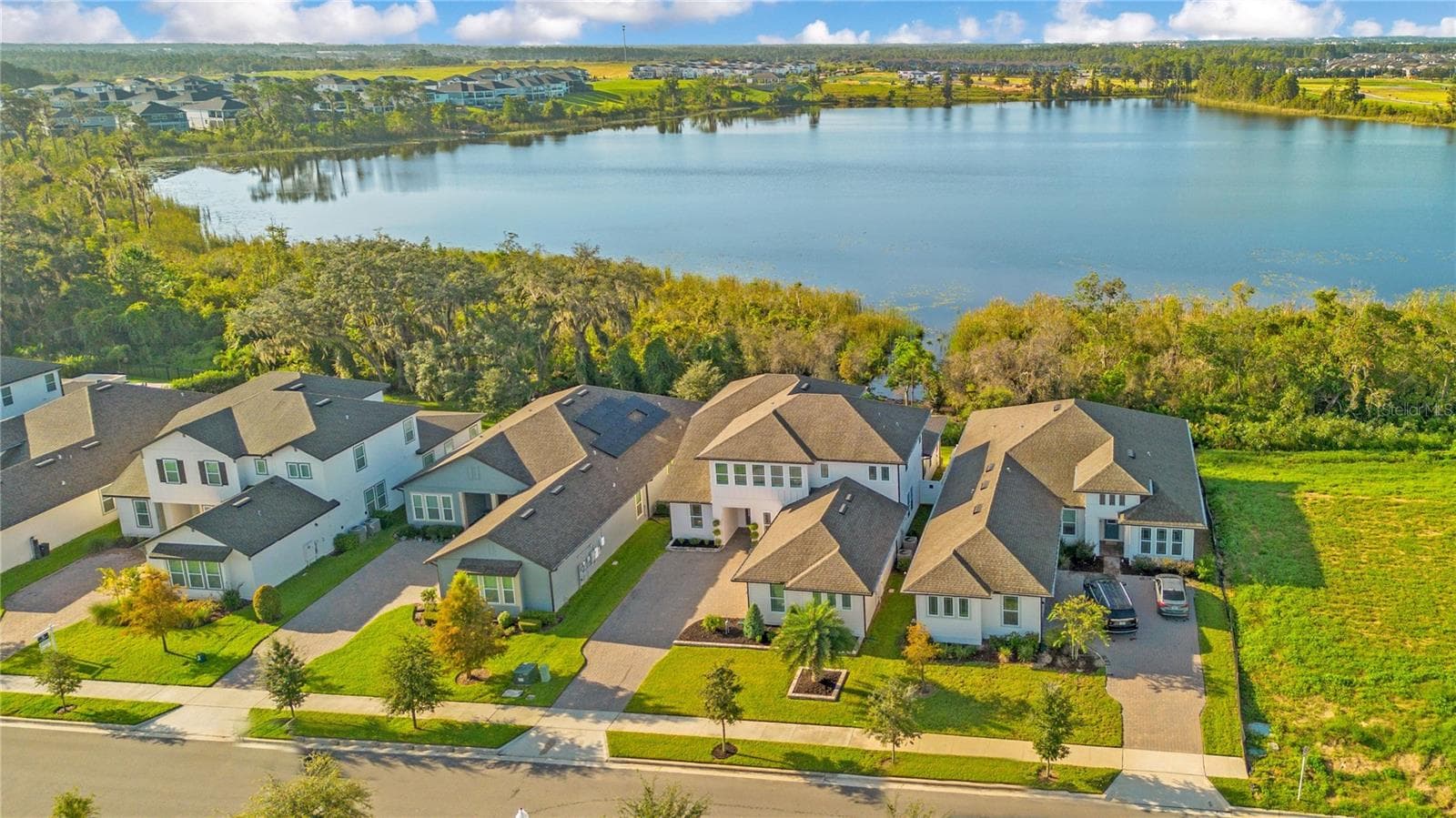 Aerial view showcasing the home’s scenic setting with the lake behind it. - 17600 LAKE STAR RD, WINTER GARDEN