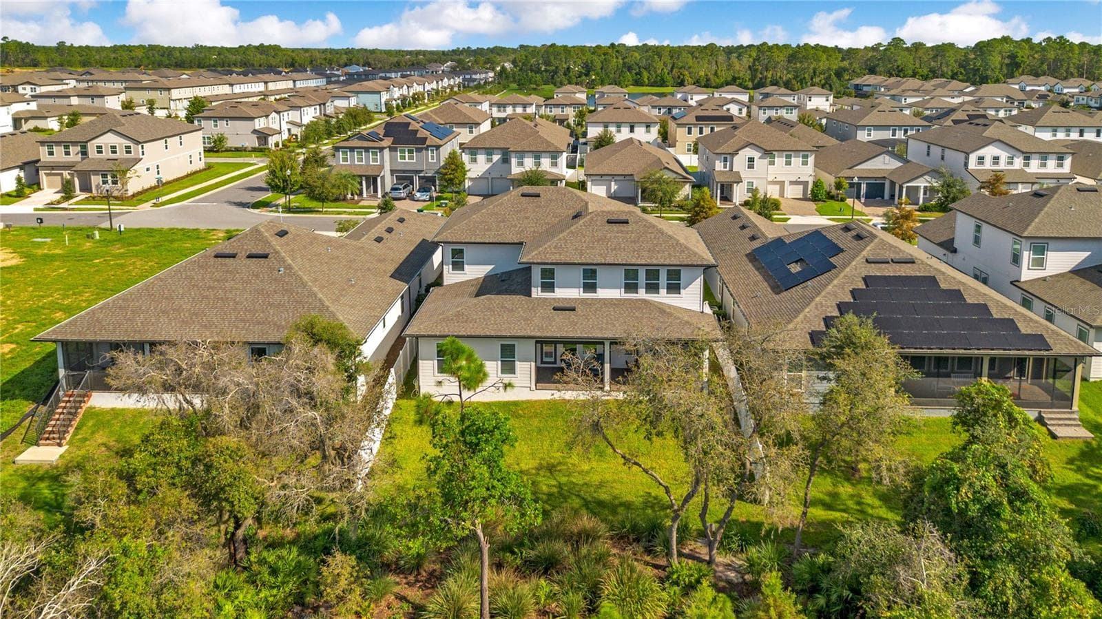 Rear aerial view highlights the spacious backyard, covered lanai and mature trees. - 17600 LAKE STAR RD, WINTER GARDEN