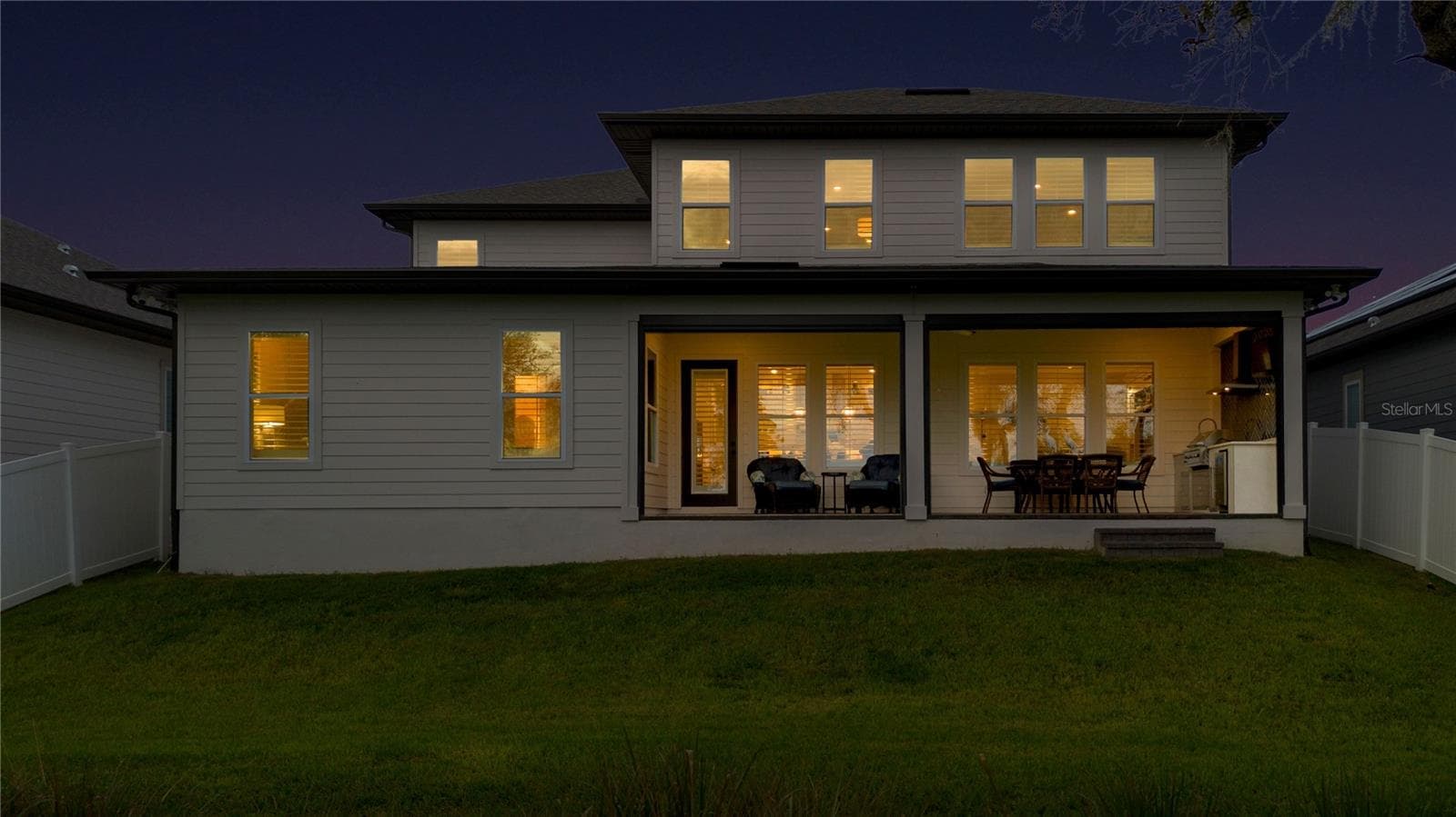 Rear twilight view featuring the covered lanai and inviting outdoor living areas. - 17600 LAKE STAR RD, WINTER GARDEN