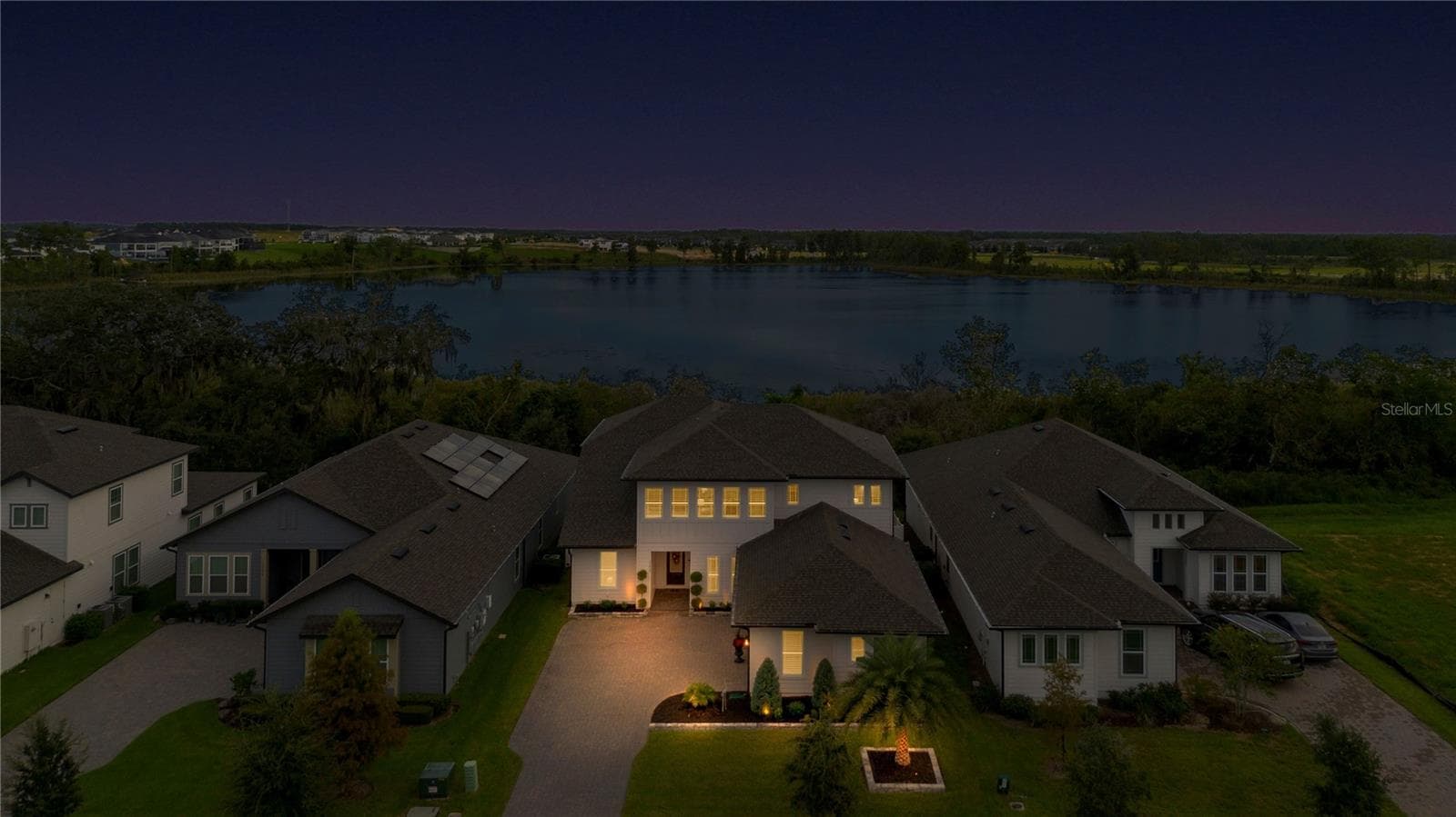 Elevated twilight view featuring the home and lake backdrop. - 17600 LAKE STAR RD, WINTER GARDEN