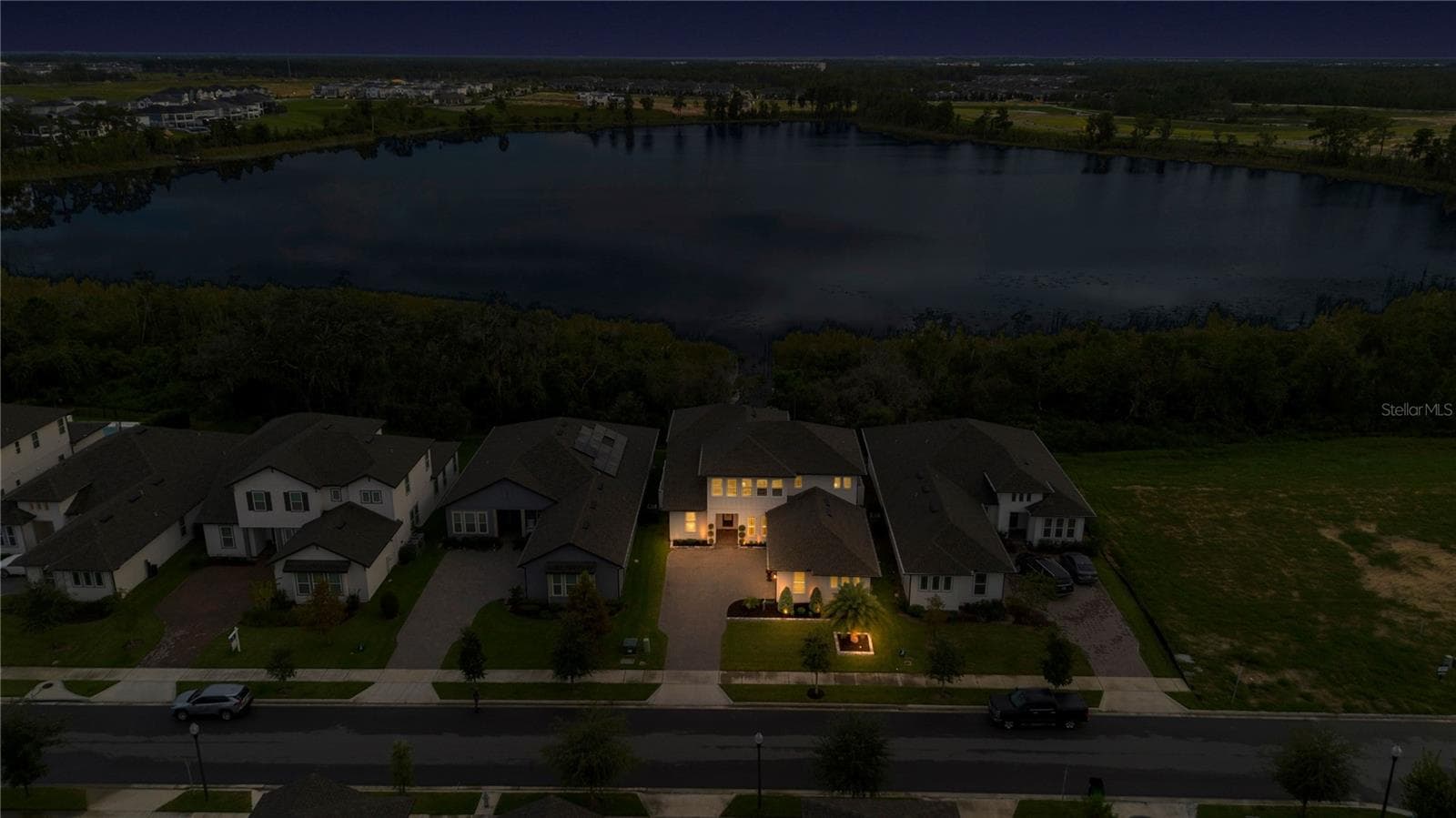 Wide twilight aerial captures the property, neighboring homes and lake setting. - 17600 LAKE STAR RD, WINTER GARDEN