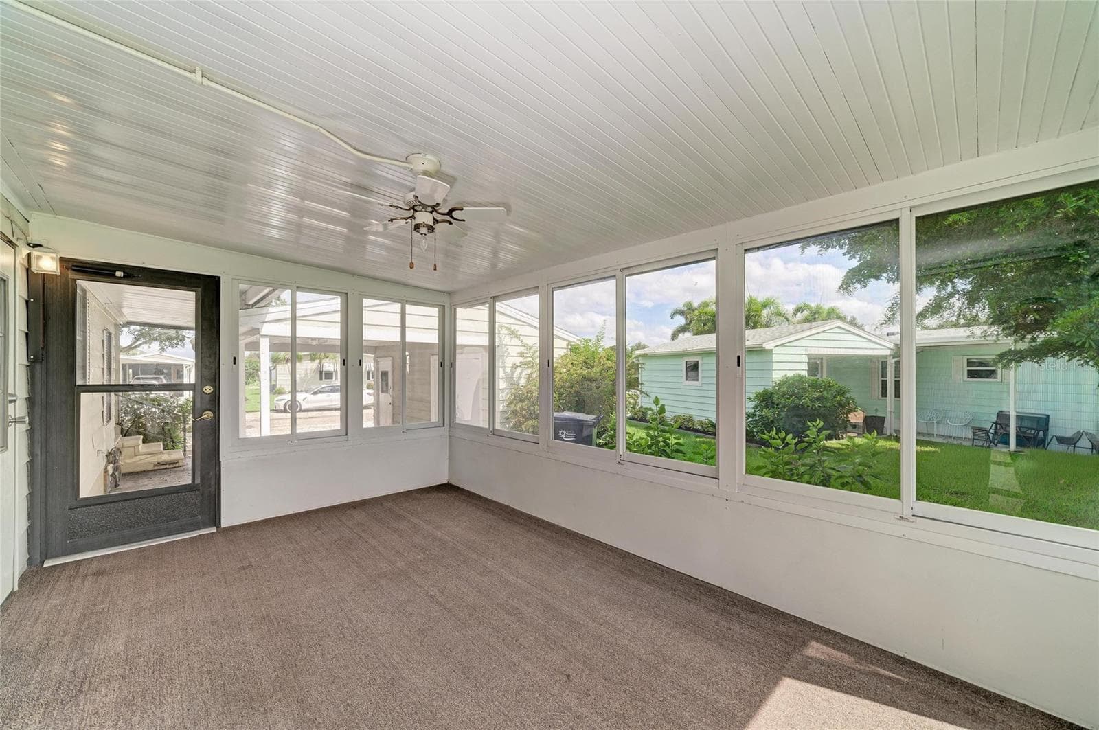 View of sunroom looking out to carport - 42 MEADOWLARK CIR, ELLENTON