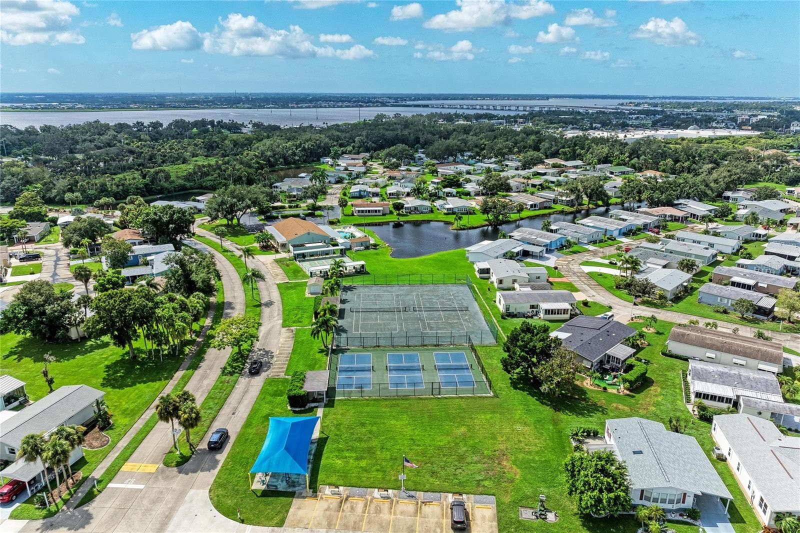 View of tennis and pickelball courts. Under the blue cover is the small fitness "gym" - 42 MEADOWLARK CIR, ELLENTON