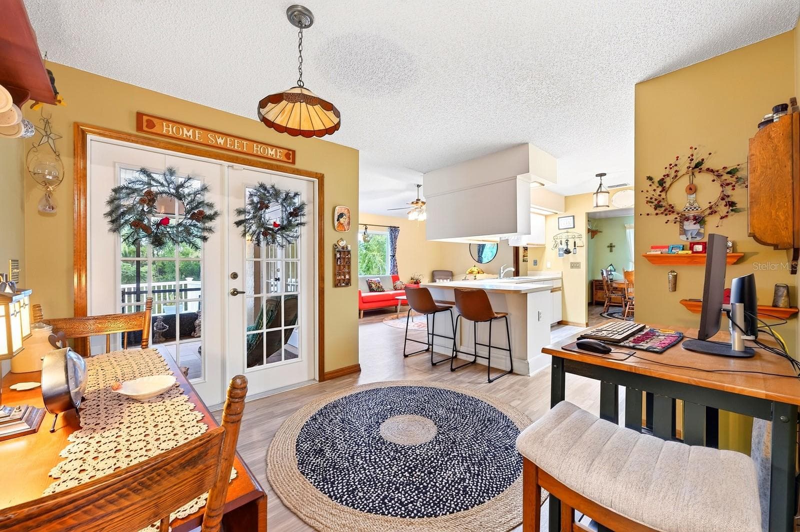 A spacious Breakfast Nook presents another inviting spot to start the day, with GLASS-PANELED FRENCH DOORS opening to the covered, enclosed FLORIDA ROOM. - 2163 NEWMARK DR, DELTONA