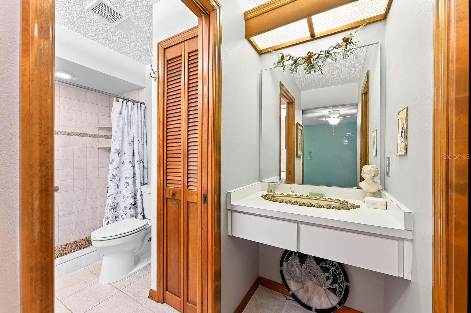 A makeup/vanity space sits between the Primary walk-in closet and en suite Bath. - 2163 NEWMARK DR, DELTONA