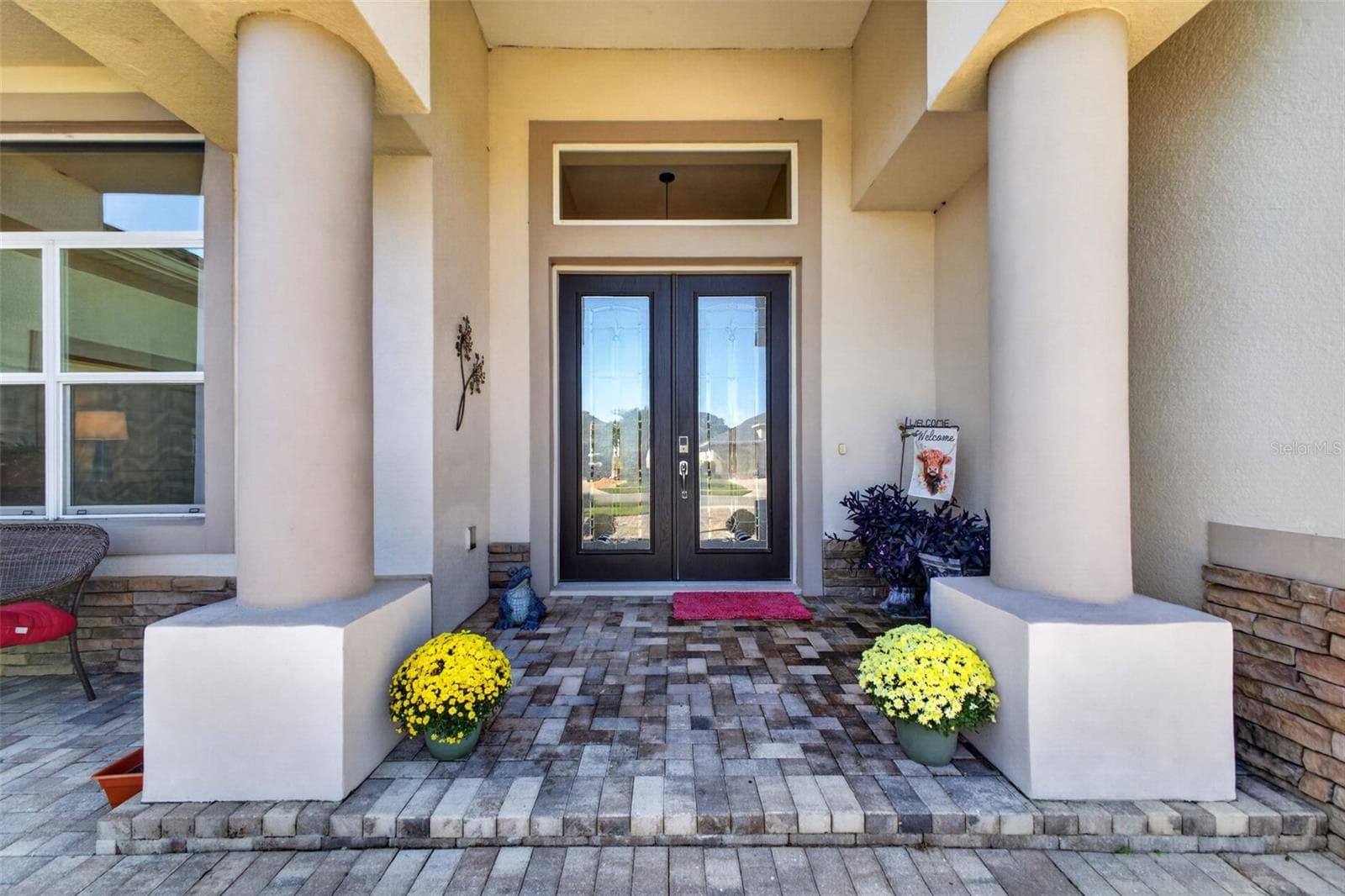 An inviting front porch sets a sophisticated tone upon arrival, complete with beveled glass double doors that seamlessly blend privacy with natural light. - 2444 PAWTUCKET PASS, MOUNT DORA