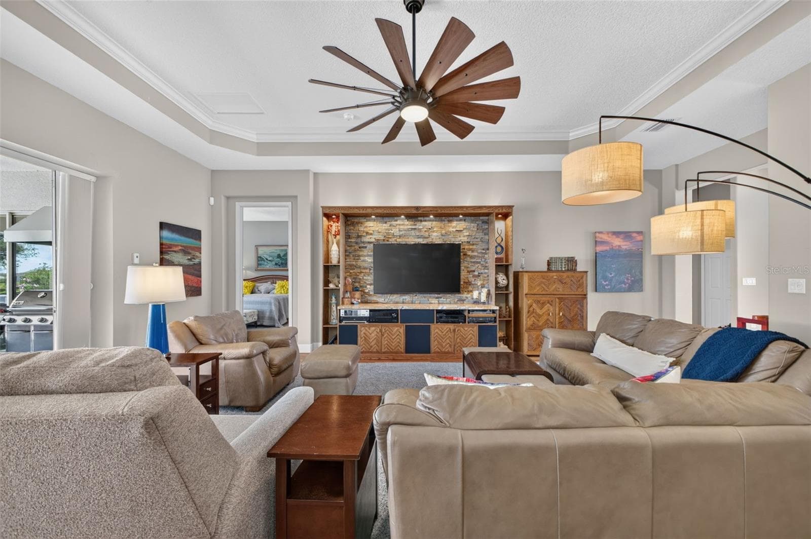 Disappearing pocket sliders open fully to merge indoor luxury with outdoor bliss, showcasing panoramic lake views and a shimmering pool. - 2444 PAWTUCKET PASS, MOUNT DORA