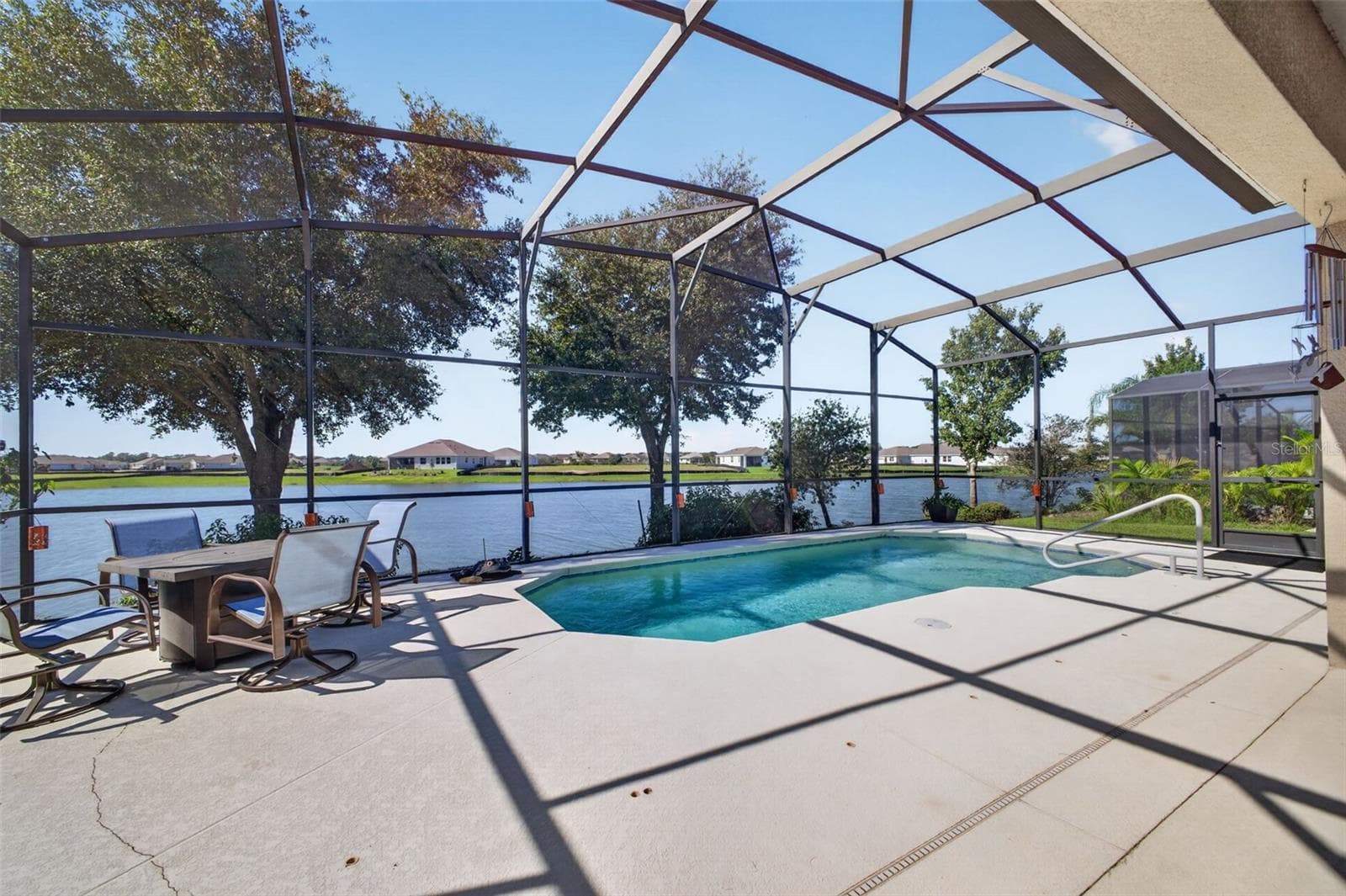 A sparkling pool set against scenic lake views creates the ultimate outdoor oasis for relaxation and entertaining. - 2444 PAWTUCKET PASS, MOUNT DORA