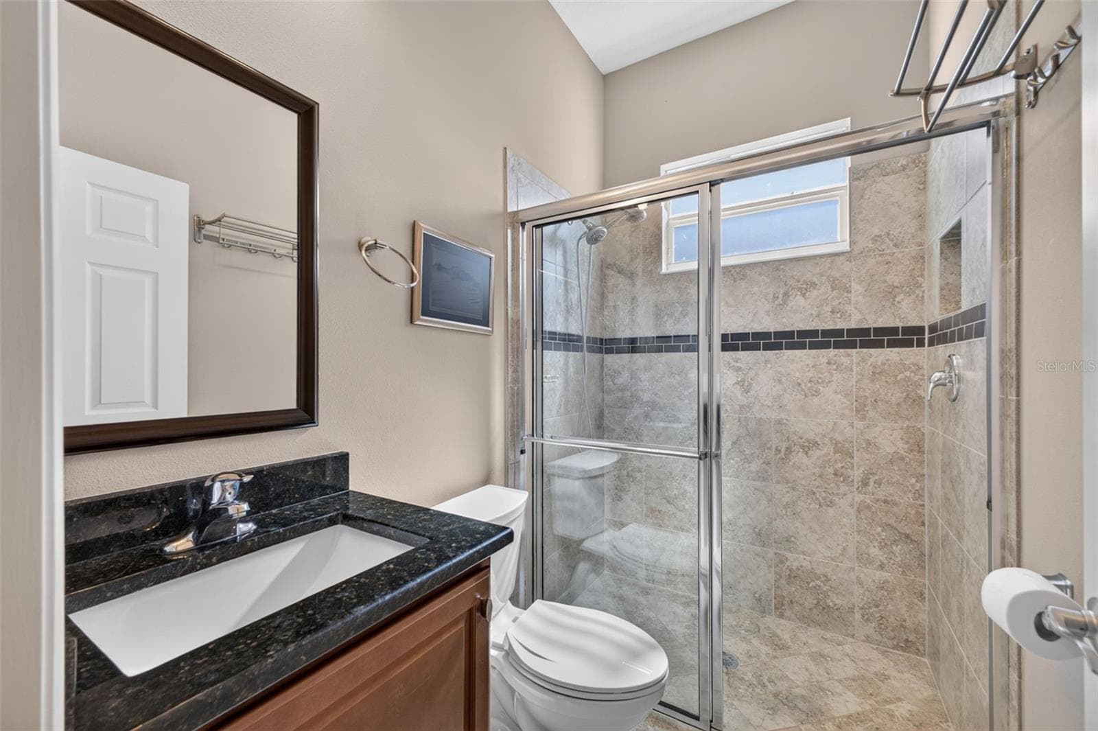 Appointed with rich granite countertops and a glass-enclosed walk-in shower, this second bath combines style and convenience. - 2444 PAWTUCKET PASS, MOUNT DORA