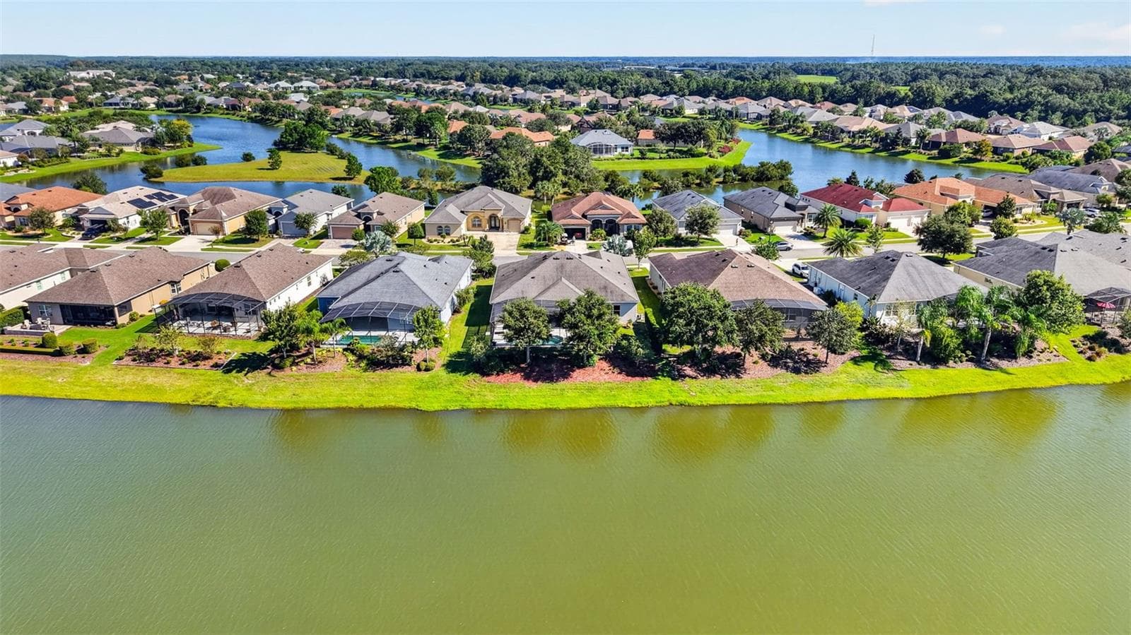 An aerial drone perspective captures the rear elevation of the home, perfectly positioned along the lake. - 2444 PAWTUCKET PASS, MOUNT DORA