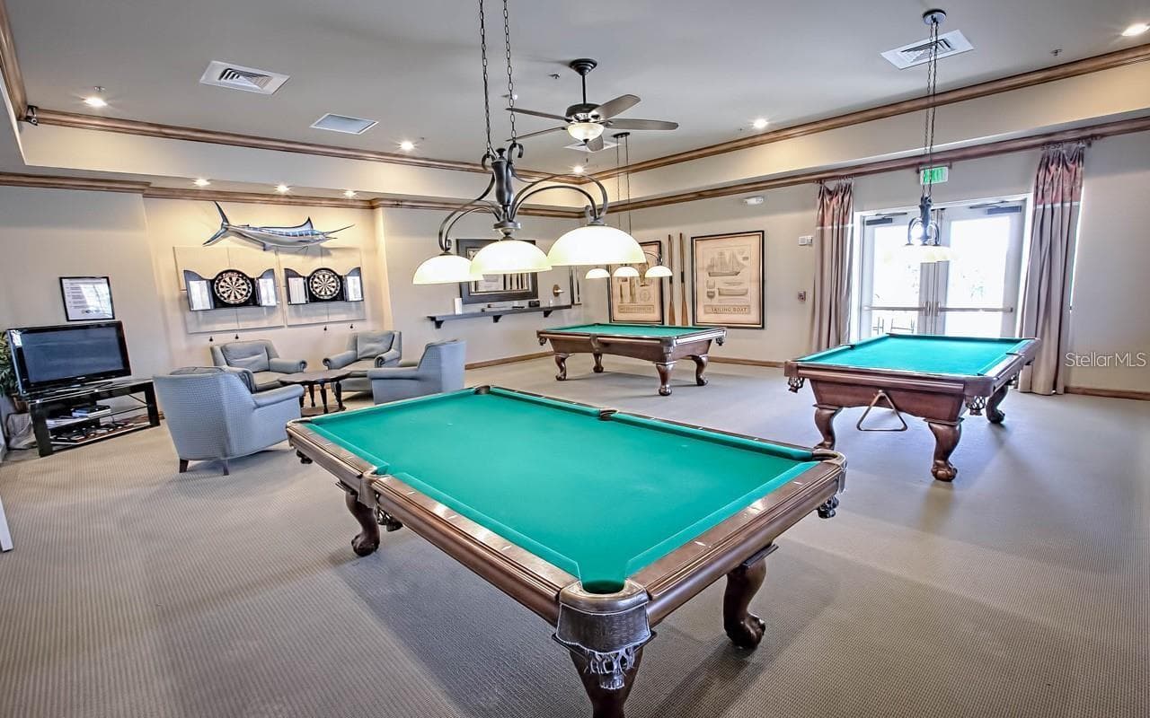 Enjoy a classic game-room experience in the dedicated billiards room, featuring pool tables and comfortable lounge seating. - 2444 PAWTUCKET PASS, MOUNT DORA