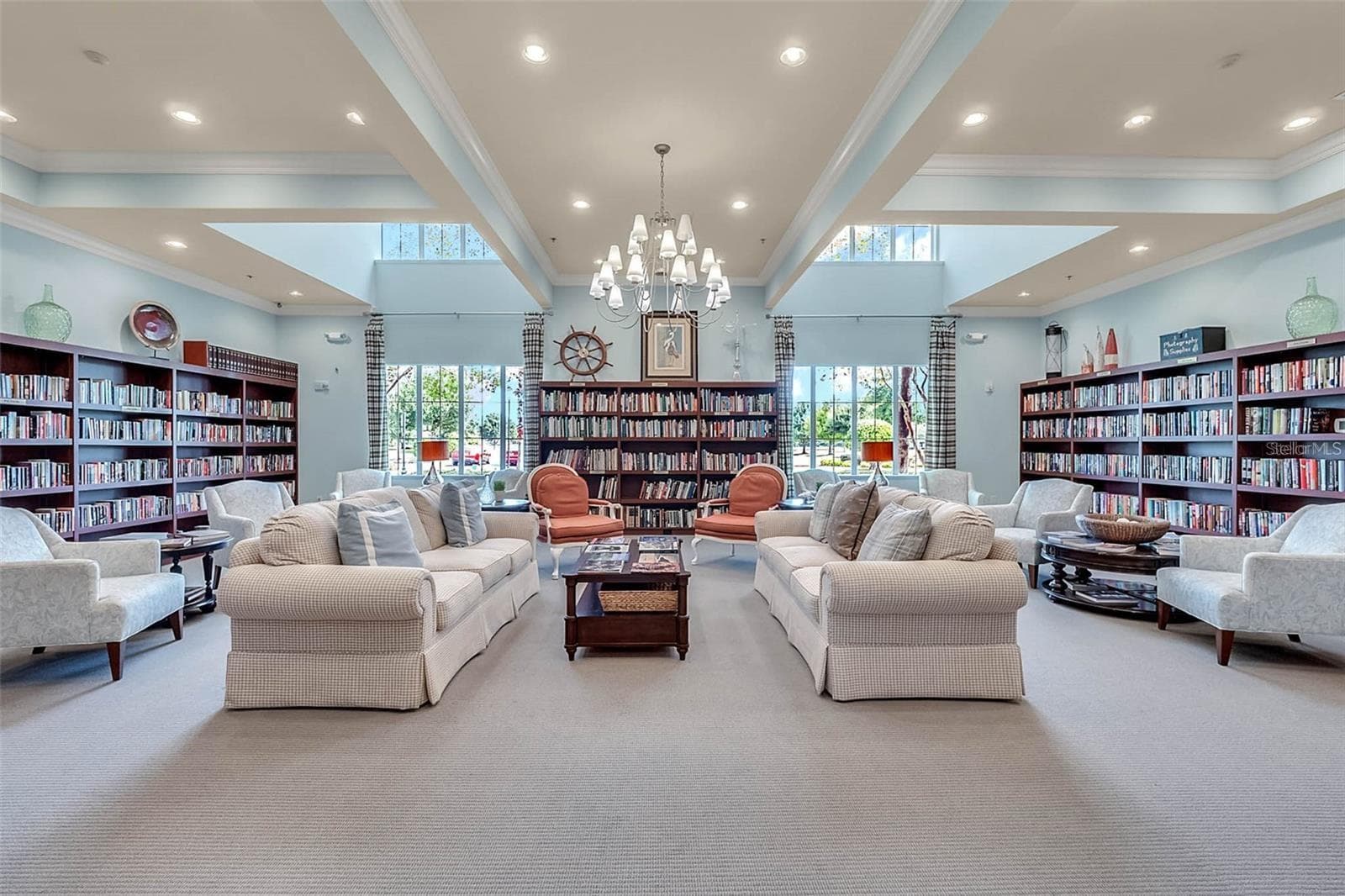 The community library offers a quiet, sunlit retreat complete with cozy seating and a rich collection of books for resident enjoyment. - 2444 PAWTUCKET PASS, MOUNT DORA