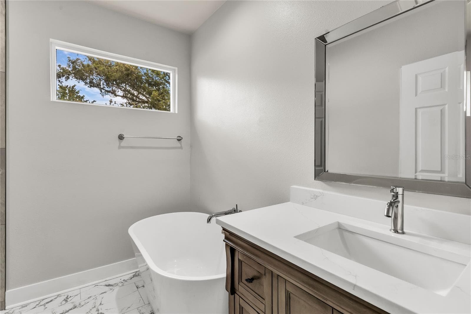 Primary bath features standalone vanity with stone countertop, soaker tub and tiled standalone shower. - 3954 S SANFORD AVE, SANFORD