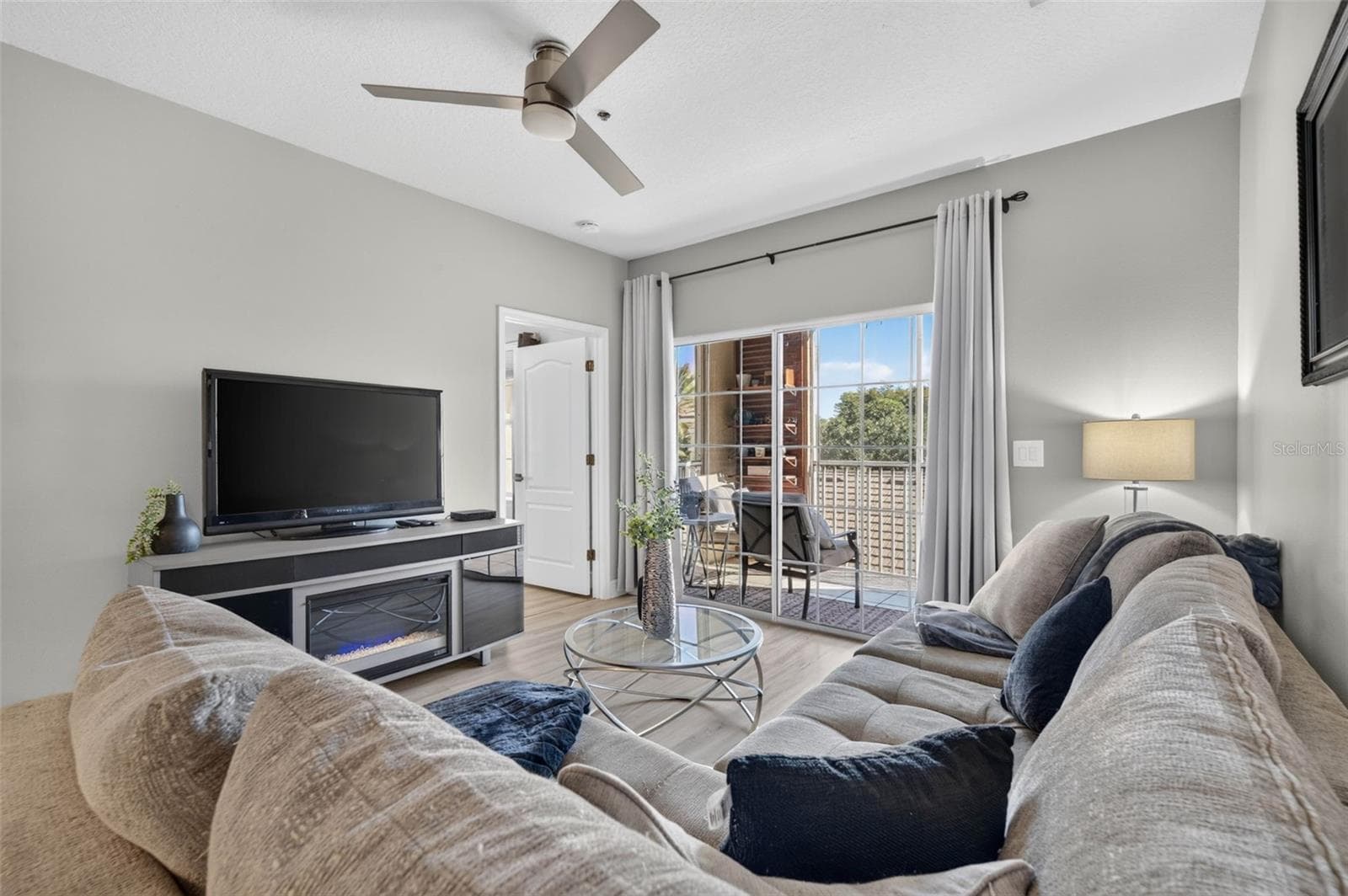 Living room with TV, ceiling fan and balcony door - 4849 CYPRESS WOODS DR #1302, ORLANDO