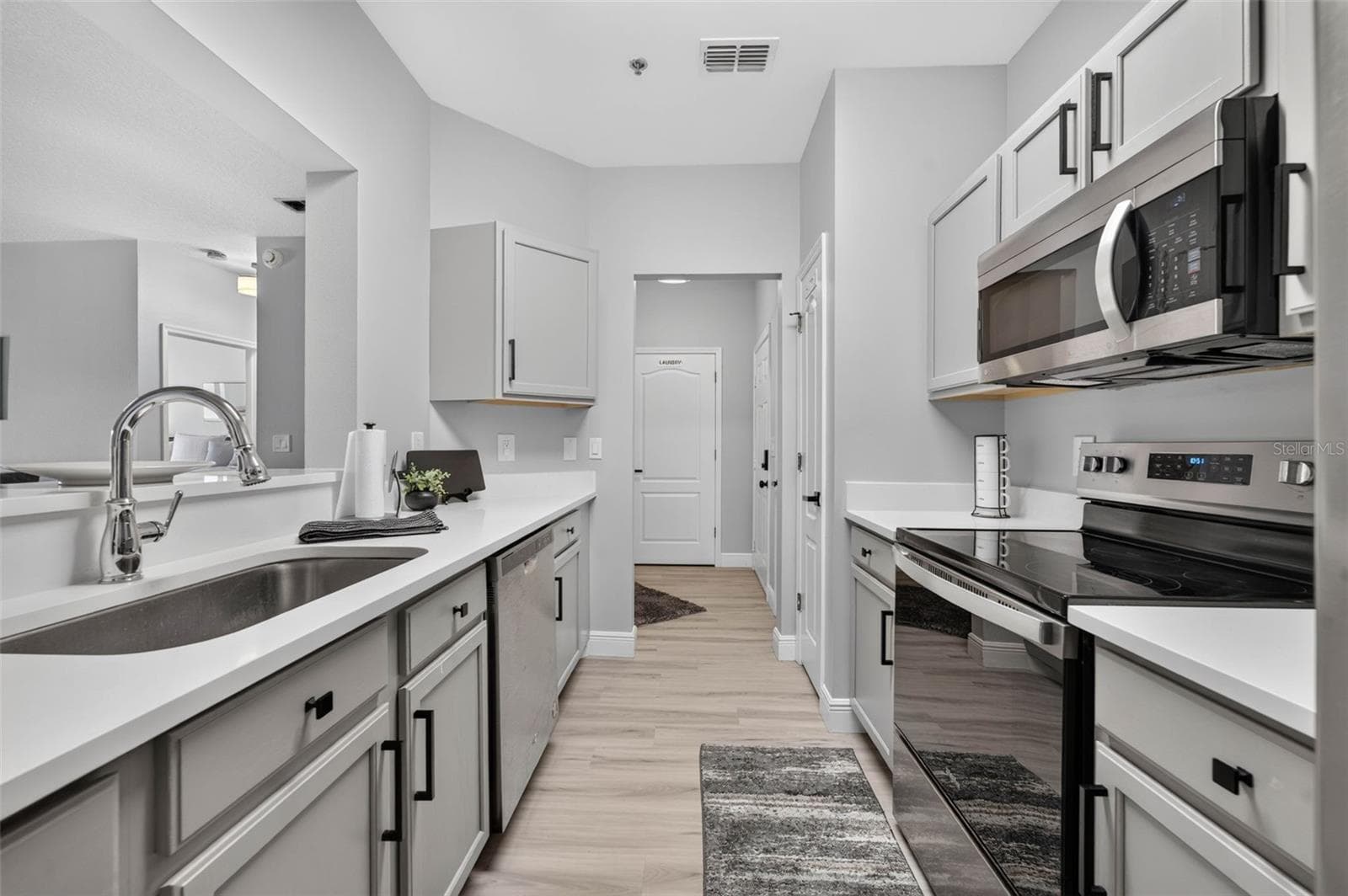 Kitchen sink with hallway beyond - 4849 CYPRESS WOODS DR #1302, ORLANDO