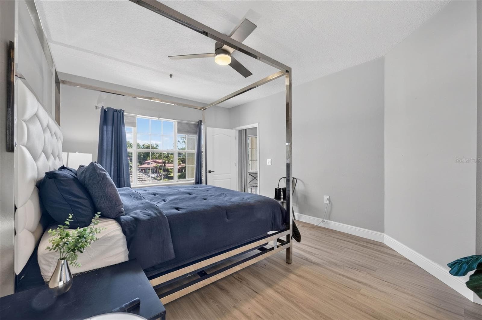 Primary bedroom with window and ceiling fan - 4849 CYPRESS WOODS DR #1302, ORLANDO