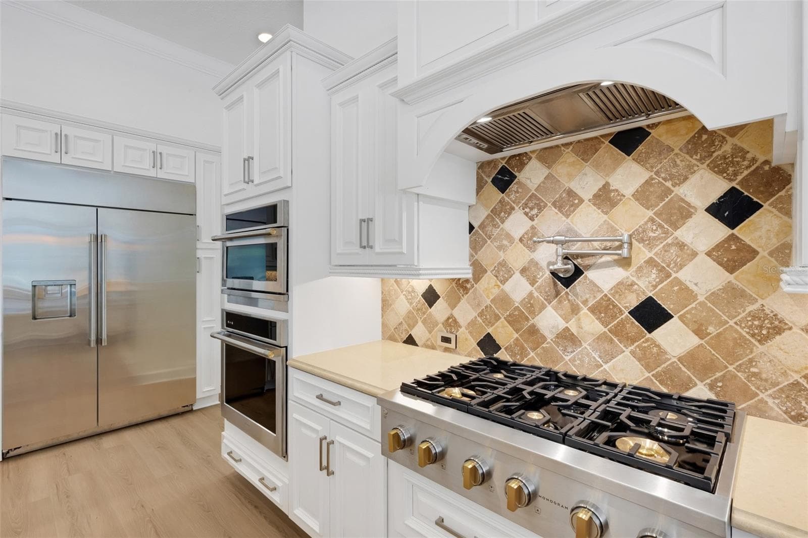 The chef's kitchen features hi-end appliances that includes a 6-burner gas cooktop, oversized built-in refrigerator, built-in ovens and warming drawer . . . - 6562 EAGLE VIEW LOOP, LAKELAND