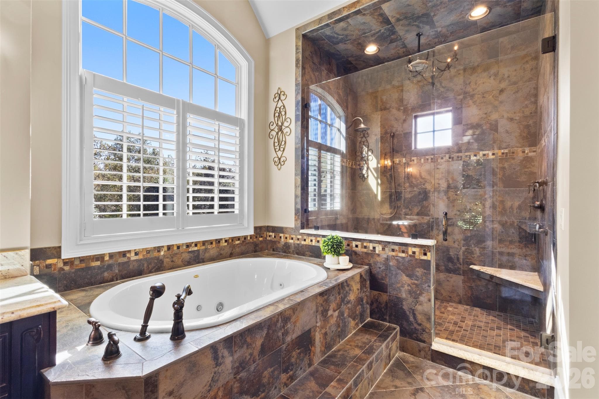 Jetted soaking tub perfect for relaxing and oversized shower with extras like a waterfall showerhead, handheld, and body jets - 973 Pinnacle Drive, Iron Station