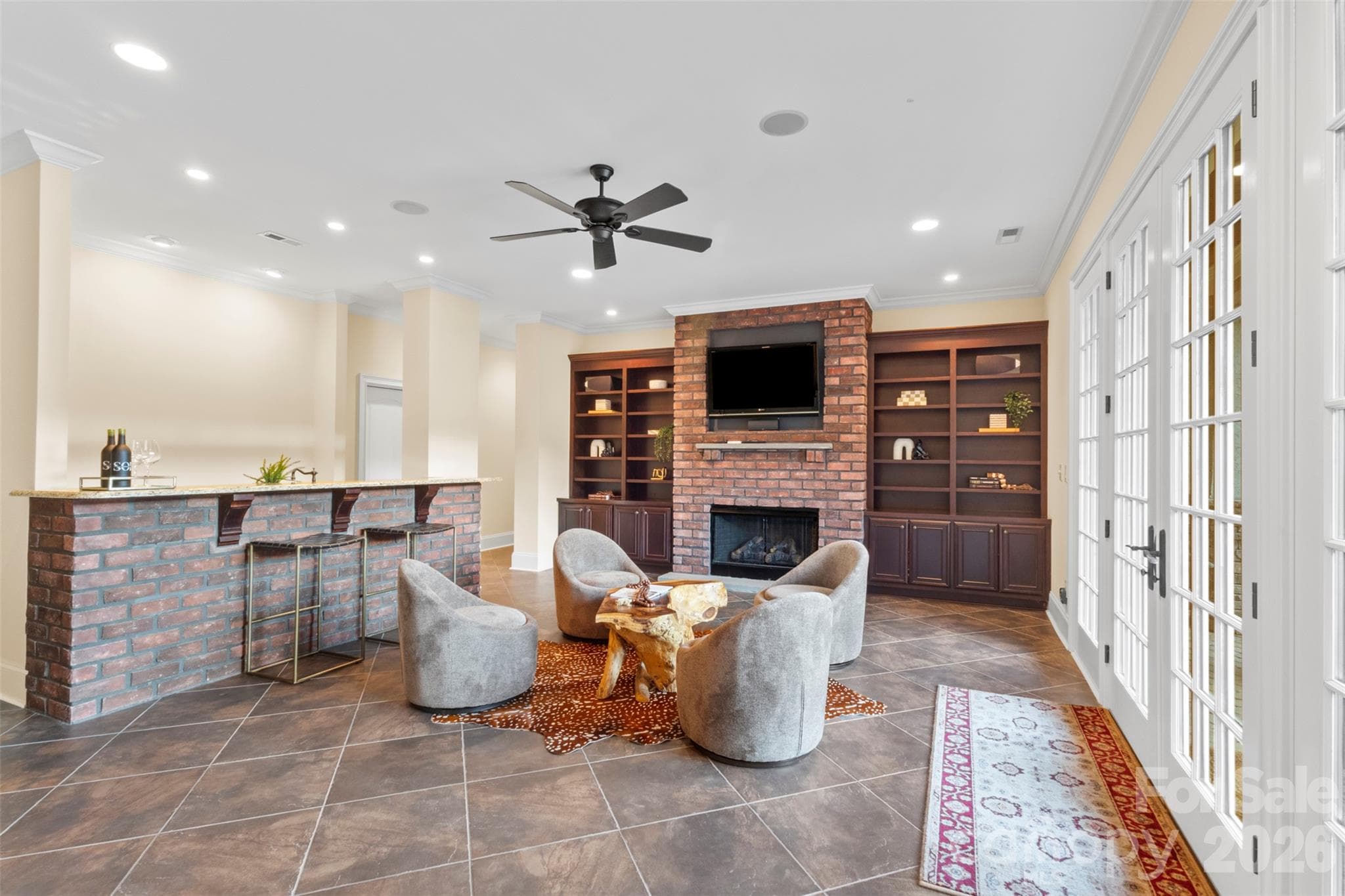 Downstairs recreation room with bar area, fireplace, whole house surround sound mechanicals, and the french doors open directly to the pool terrace - 973 Pinnacle Drive, Iron Station