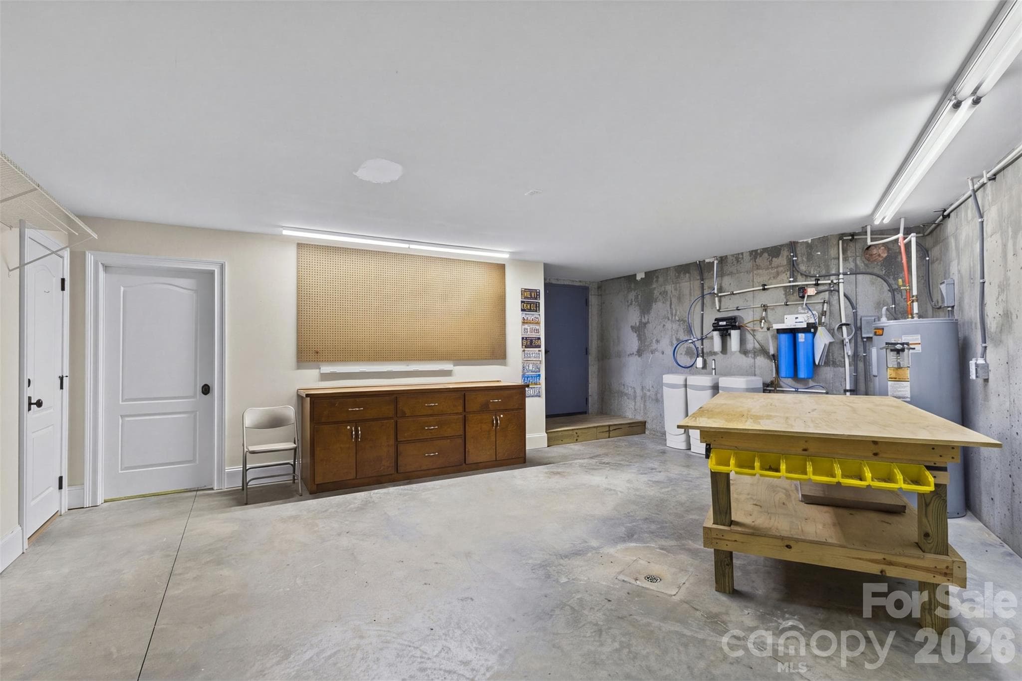 Dedicated workshop also in the unfinished space with rolling work tables that convey, dedicated paint-storage closet with fire-retardant drywall and door, and the whole house water treatment system is located here - 973 Pinnacle Drive, Iron Station