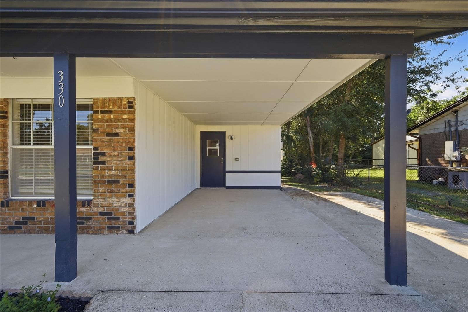 Carport with door to interior utility room. - 330 BROOKLYN AVE, ORANGE CITY