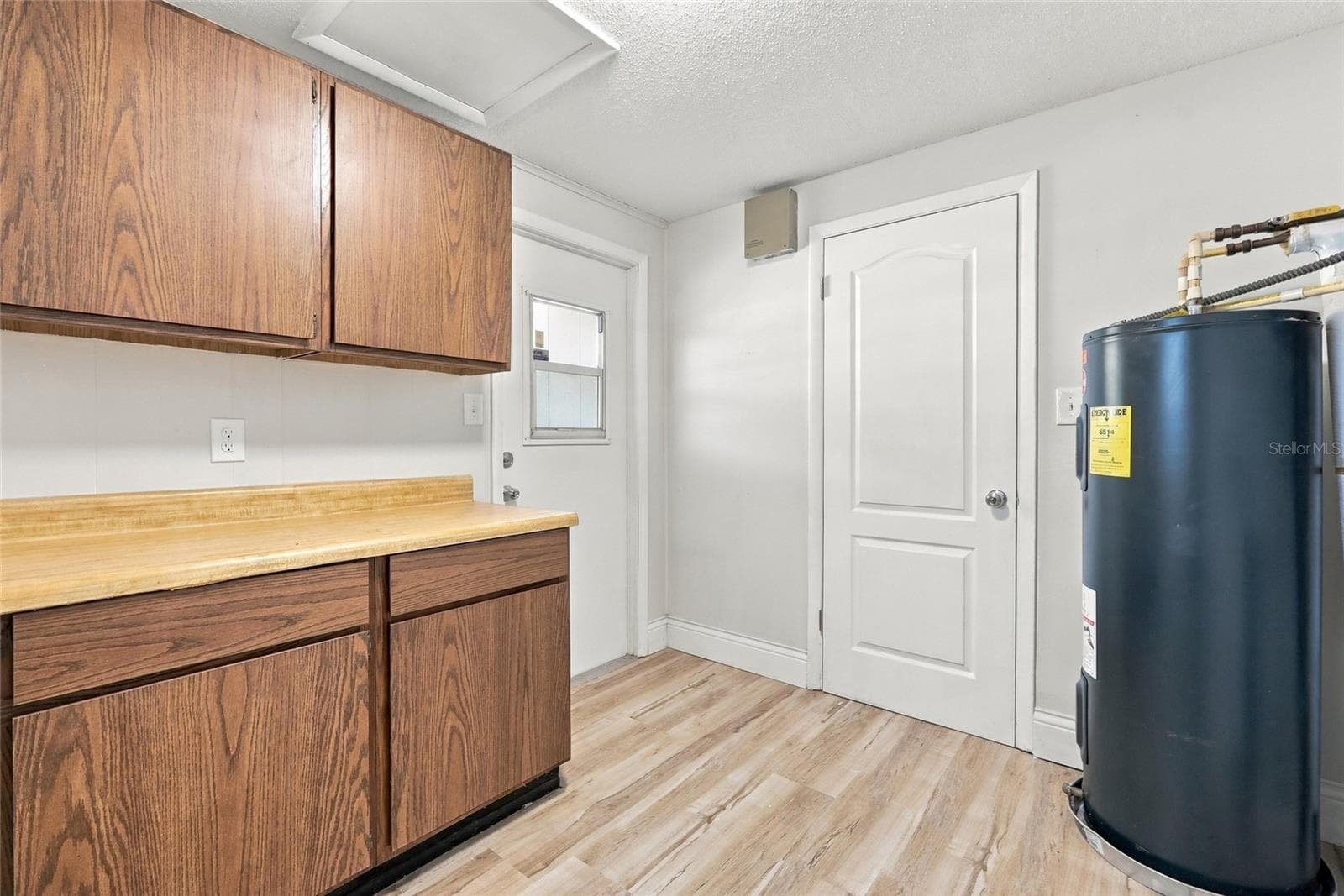 Inside utility with cabinets with left door to carport and other to dining area. - 330 BROOKLYN AVE, ORANGE CITY