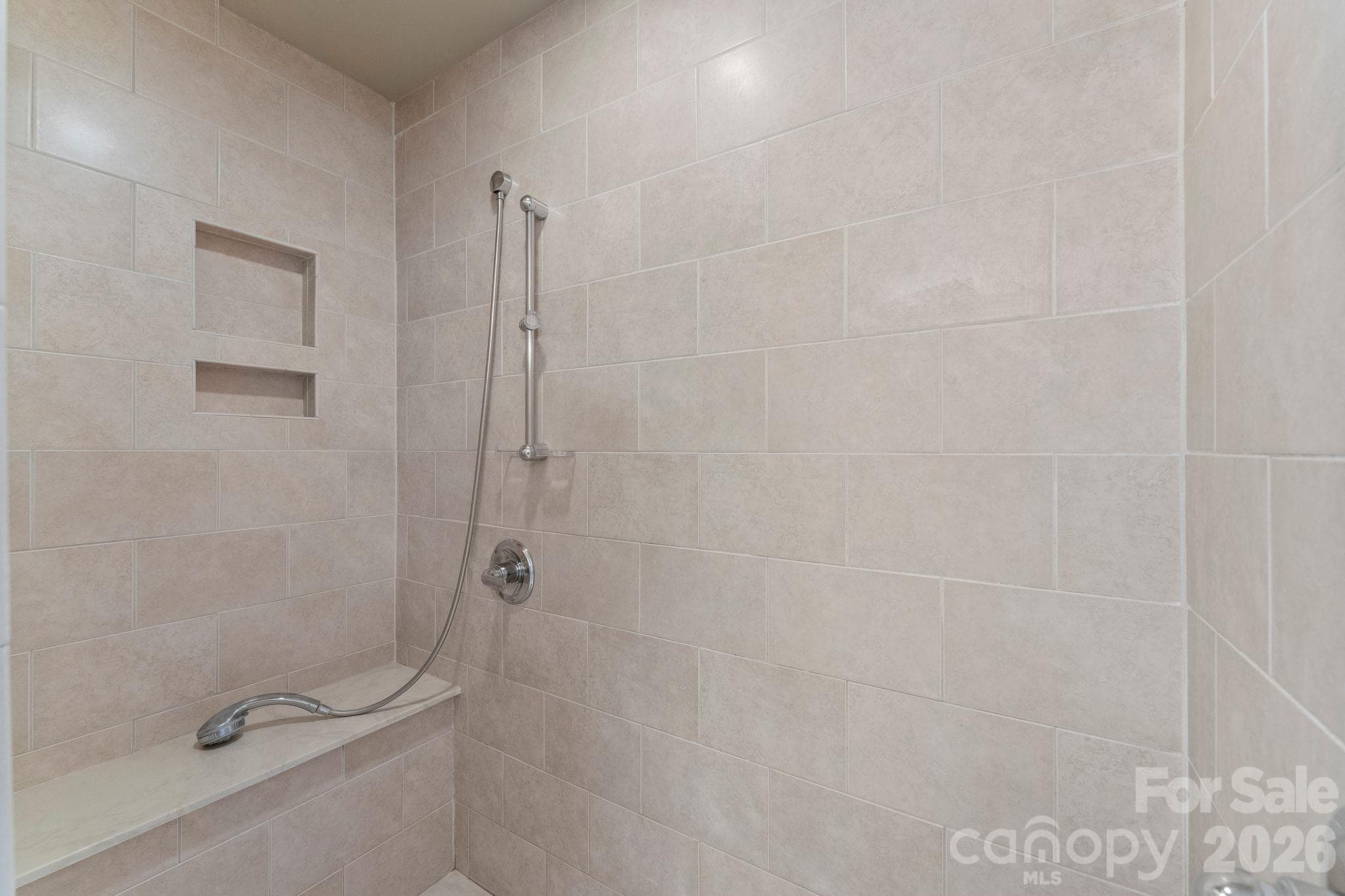 Large tiled shower with bench and niche in the Primary Bathroom - 2006 Grey Road, Davidson
