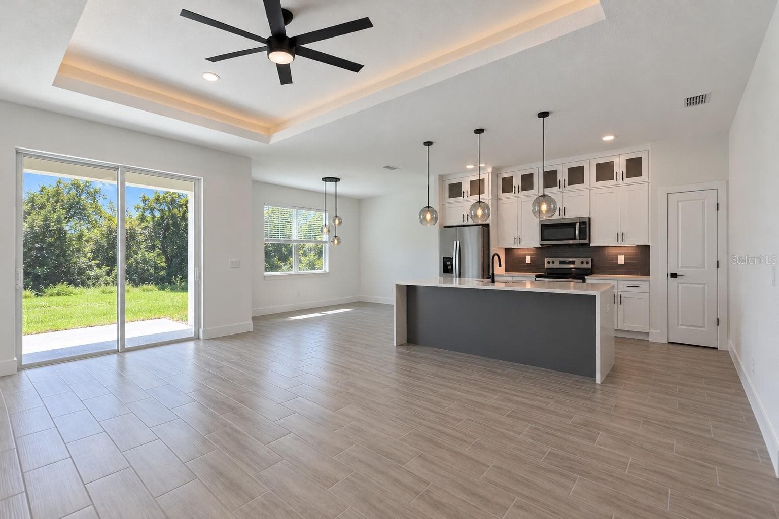 Open living and kitchen. Digitally edited model/property composite. - 24479 SW KINGSWAY CIR, ARCADIA