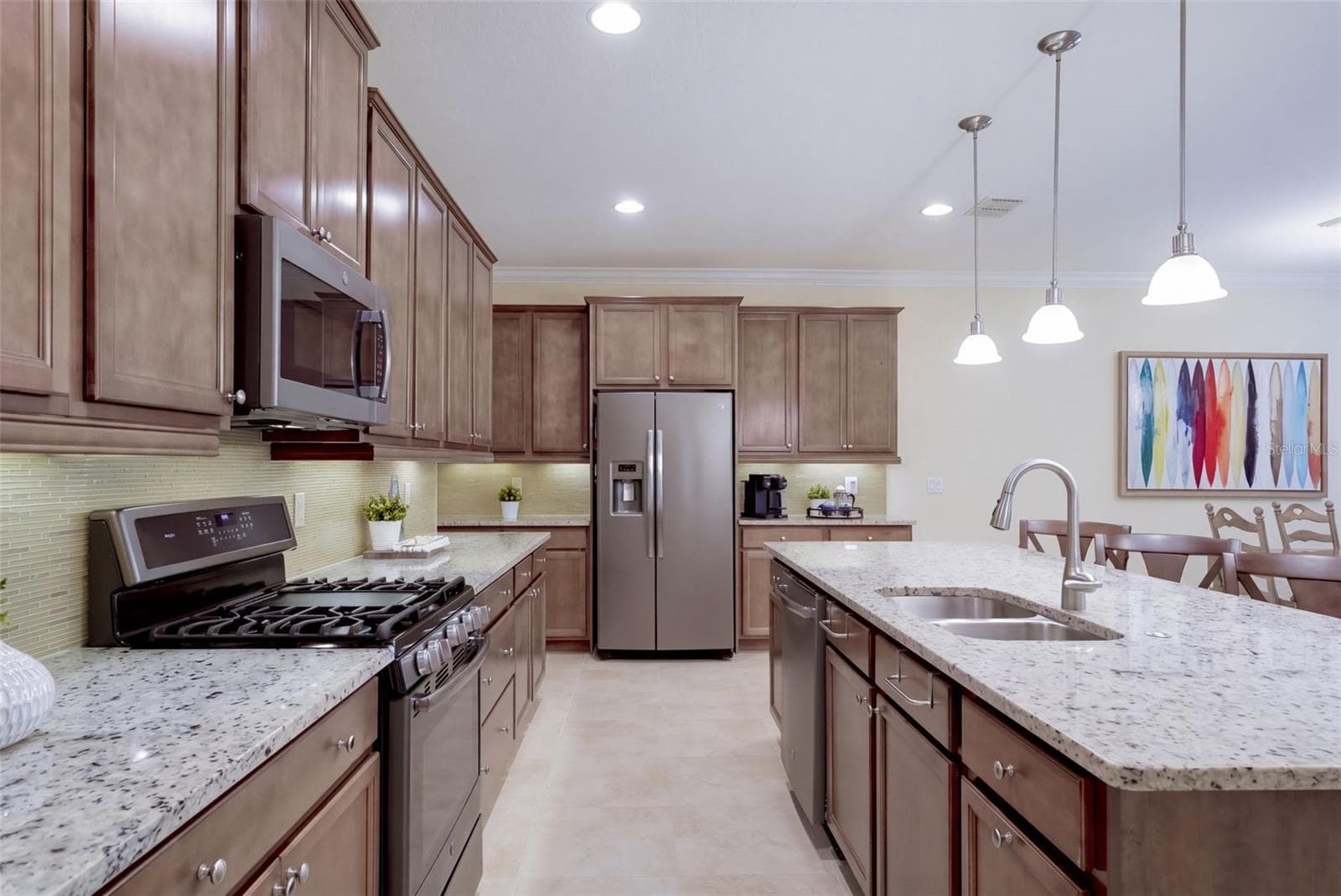Kitchen w/ a 5-burner natural gas convention range, stainless steel appliances & pendant lighting above breakfast island - 1233 EGGLESTON DRIVE, DELAND