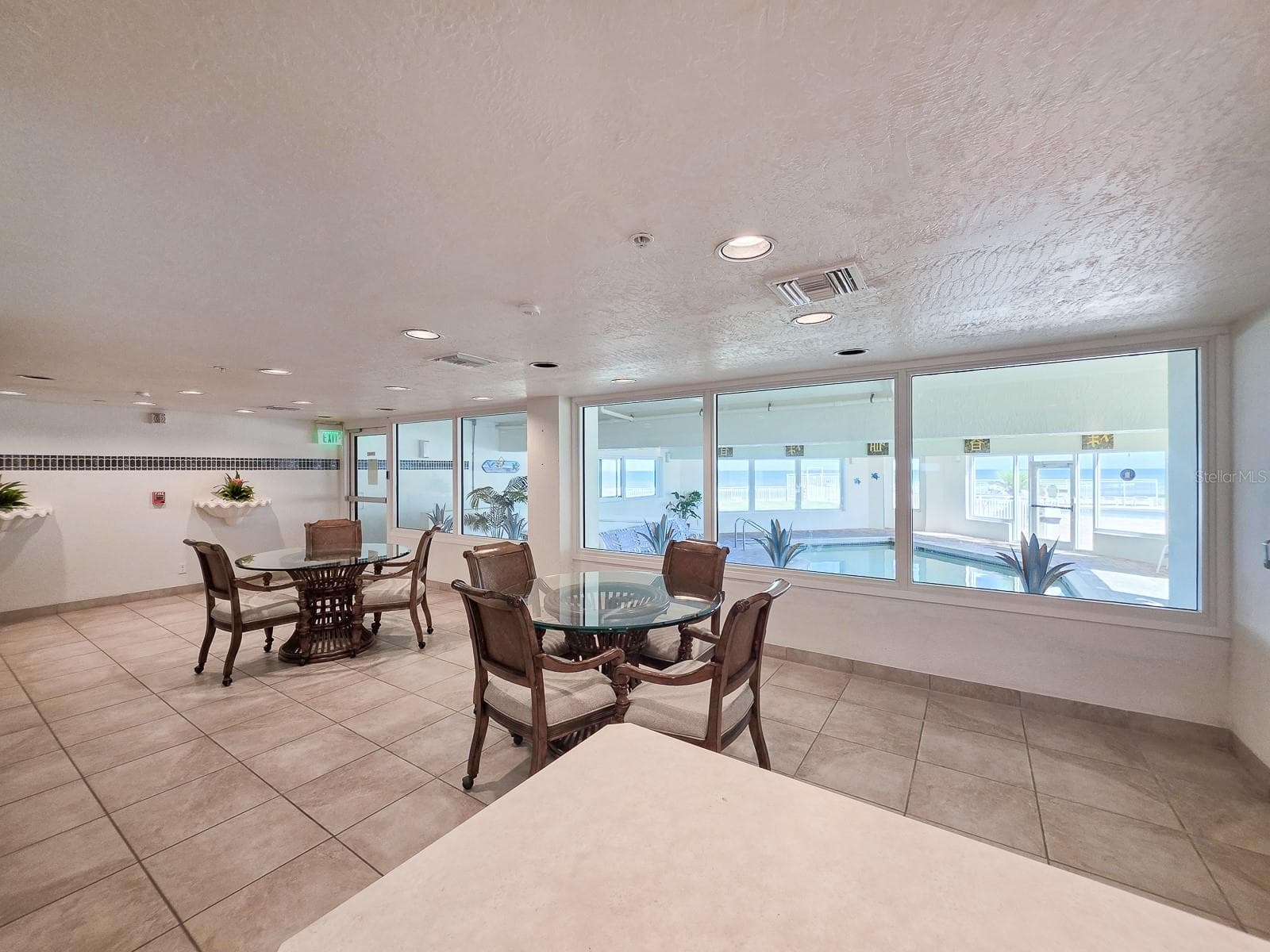 Community room with kitchen and view of the indoor heated pool - 2545 S ATLANTIC AVE #403, DAYTONA BEACH SHORES