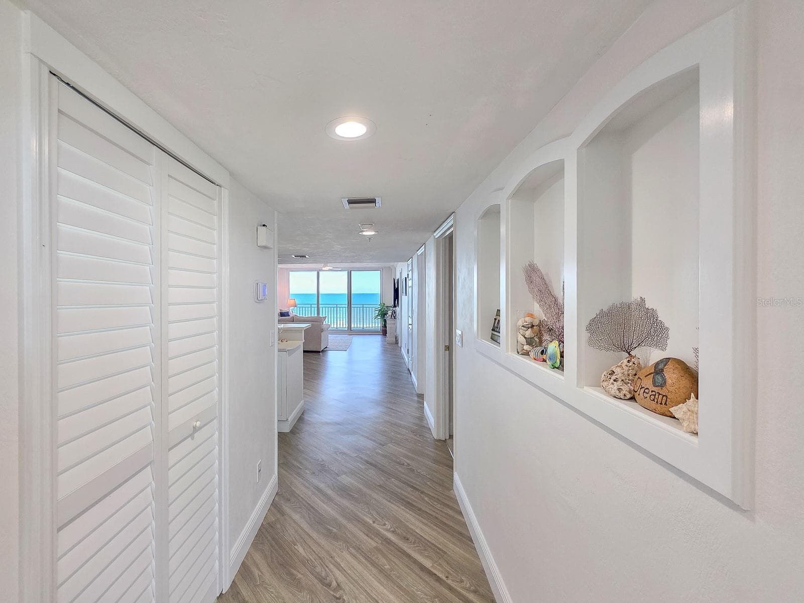 Hallway with laundry on left and built-ins on left. - 2545 S ATLANTIC AVE #403, DAYTONA BEACH SHORES