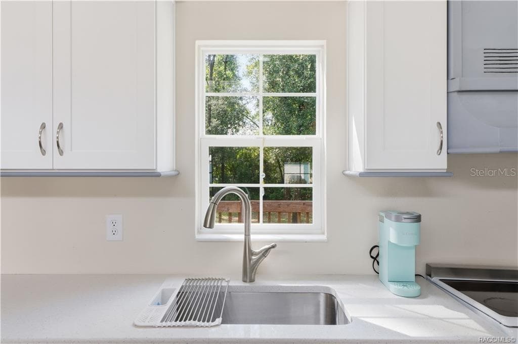 Kitchen Sink & Window – Stainless-steel sink w/pull-down faucet, solid surface countertop & window overlooking the greenery outside. - 6230 W GLEN ROBBIN CT, CRYSTAL RIVER