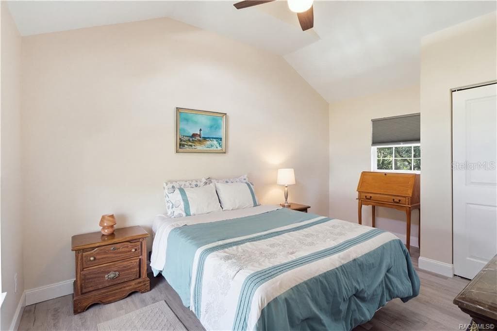 Primary Bedroom – Cozy & inviting bedroom featuring VAULTED CEILINGS, luxury vinyl plank flooring, ceiling fan & coastal-inspired furnishings. - 6230 W GLEN ROBBIN CT, CRYSTAL RIVER
