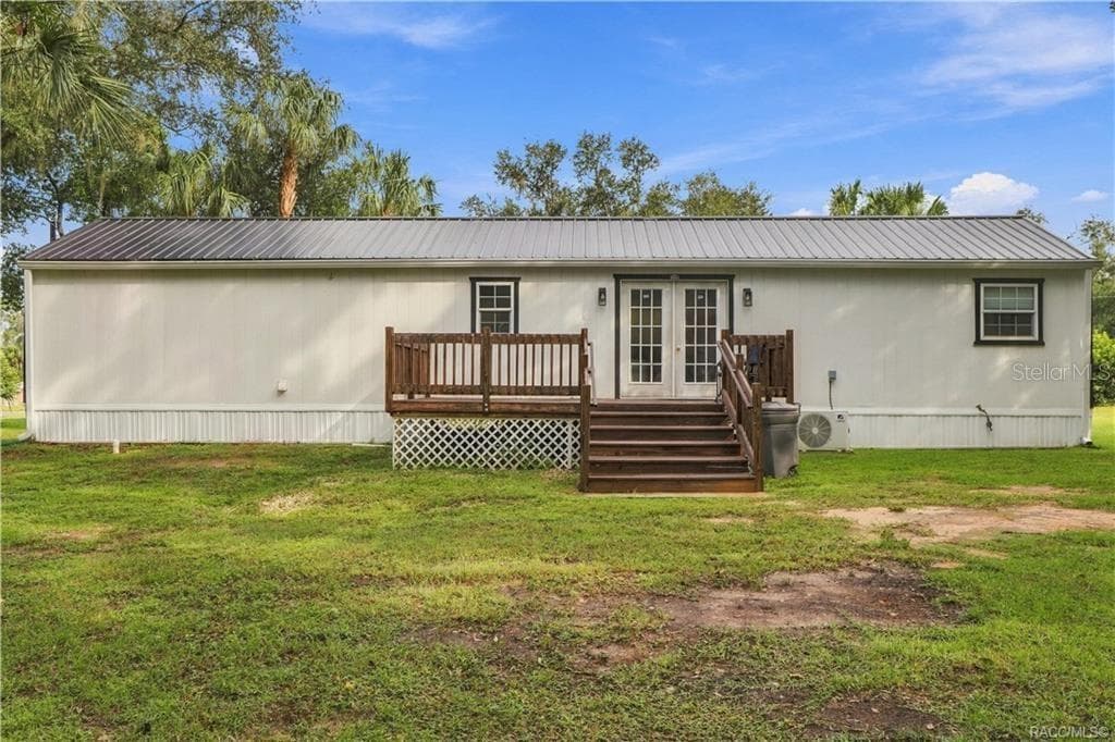 Rear Exterior – Attractive rear elevation featuring the METAL ROOF, French doors, wooden deck w/steps & a MINI-SPLIT HEATING & COOLING SYSTEM. - 6230 W GLEN ROBBIN CT, CRYSTAL RIVER
