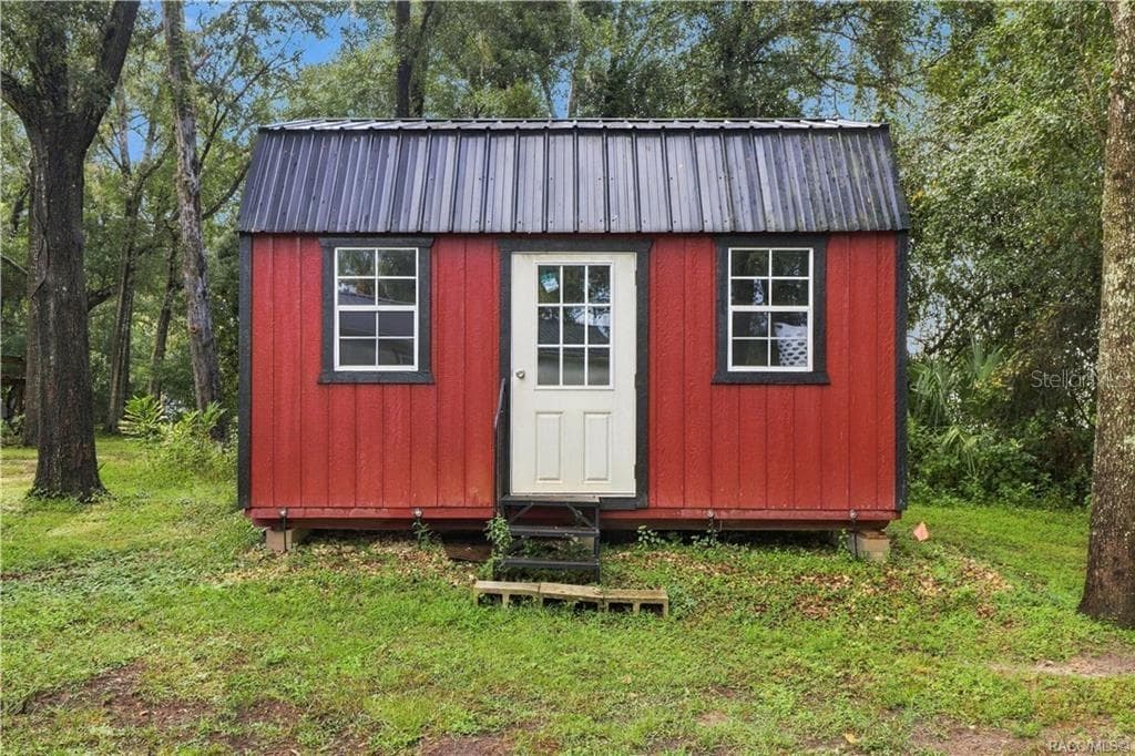 Detached Storage Building – Charming RED DETACHED STORAGE BUILDING featuring a METAL ROOF, double windows & convenient entry door. A wonderful addition for storing lawn equipment, tools or outdoor essentials! - 6230 W GLEN ROBBIN CT, CRYSTAL RIVER