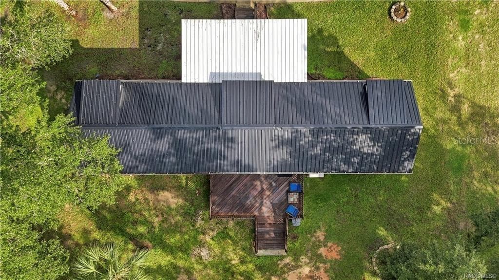 Aerial Roof & Deck View – Bird's-eye perspective showcasing the METAL ROOF, covered front porch, spacious WOODEN REAR DECK & surrounding green space. - 6230 W GLEN ROBBIN CT, CRYSTAL RIVER