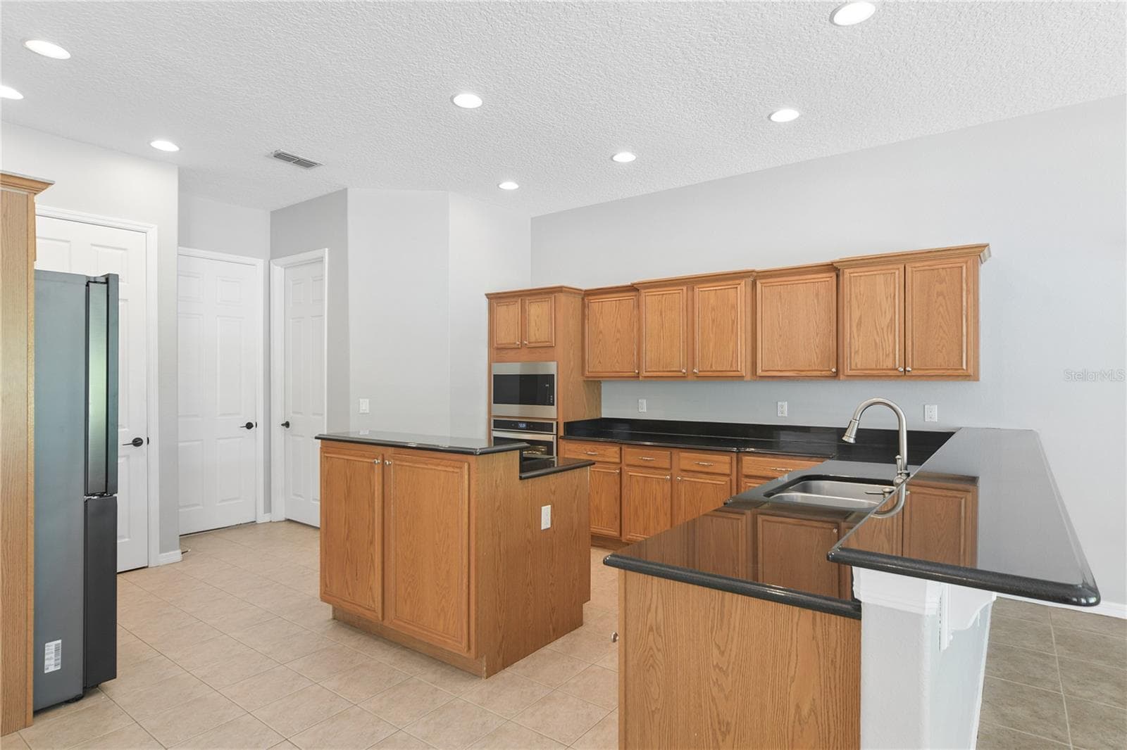 Continuing thru to the kitchen that has updated appliances including an ice maker and wine fridge. This is also open concept to a breakfast nook/dinette and the family room. - 16169 BRISTOL LAKE CIR, ORLANDO