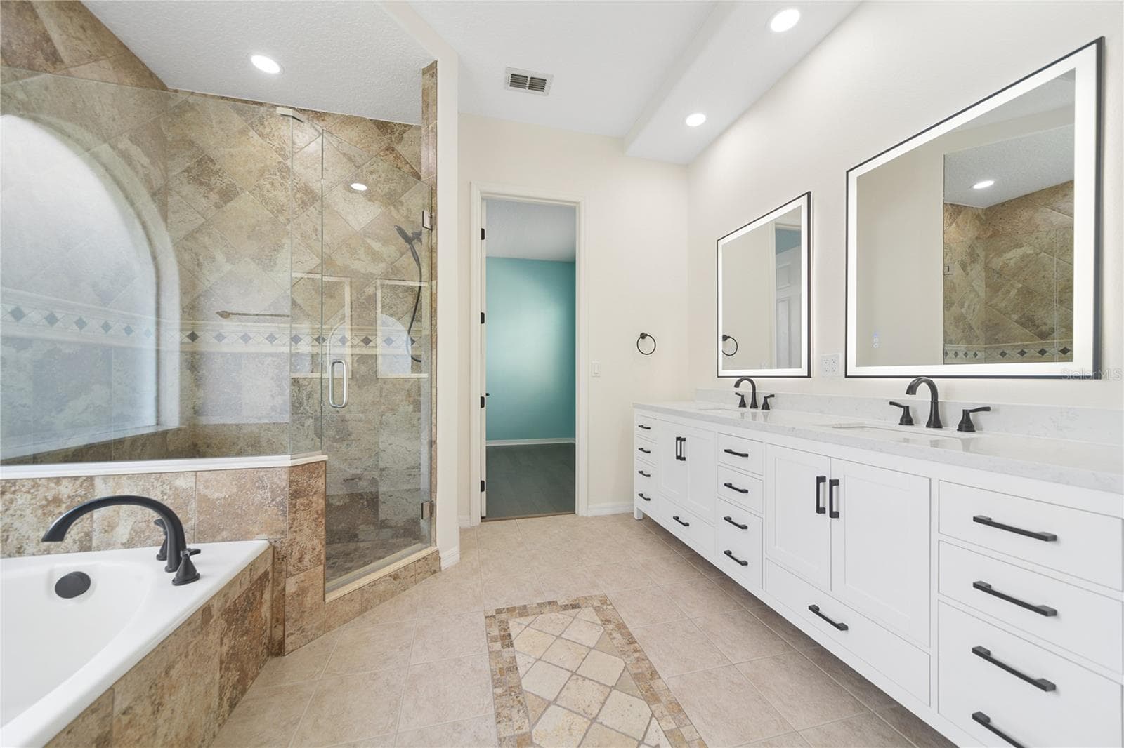 Enjoy this bright and beautifully updated private primary bathroom with garden tub, separate shower, and double vanity with dual sinks. - 16169 BRISTOL LAKE CIR, ORLANDO